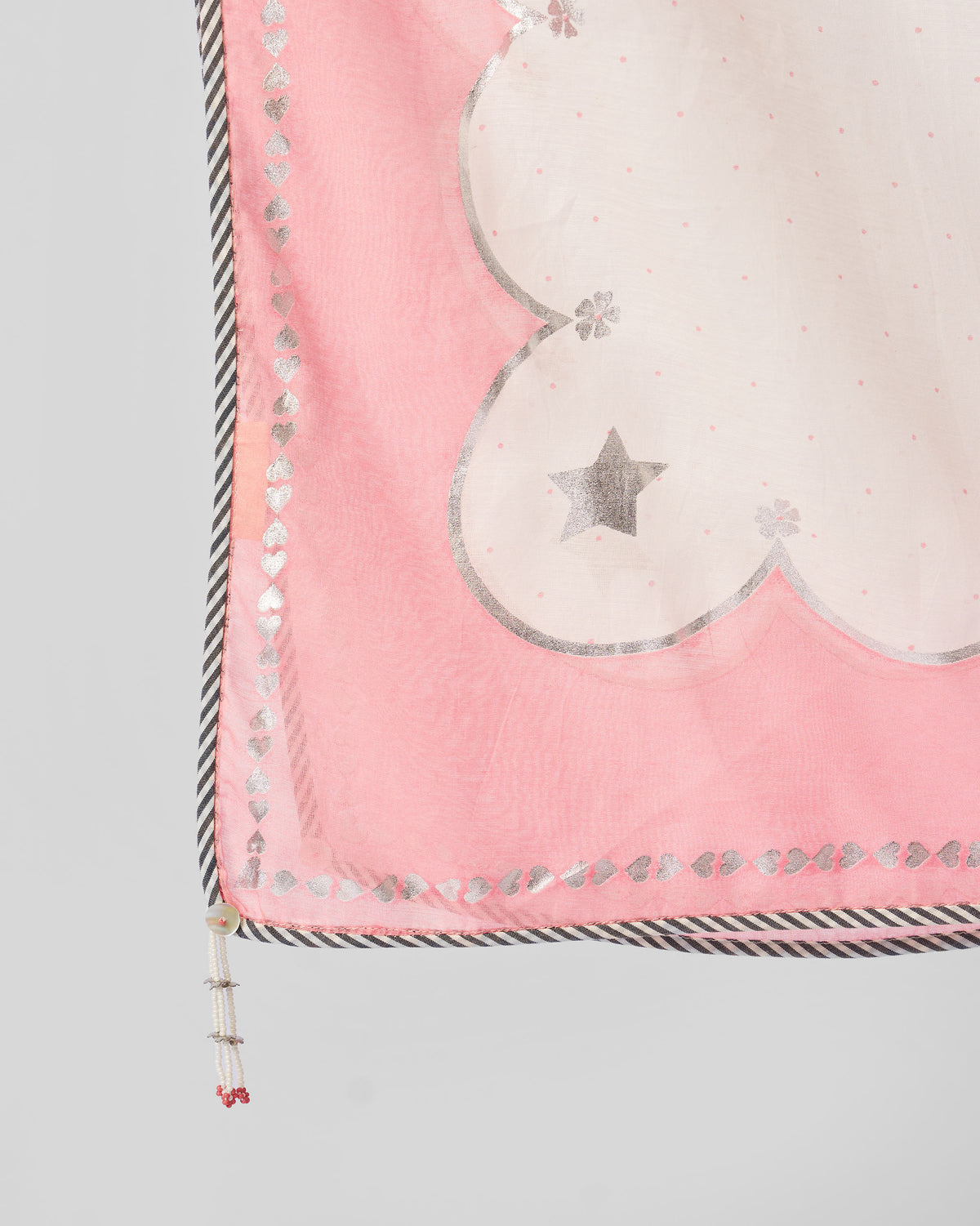 Close-up of Keya Dupatta corner with a silver star and white tassel.