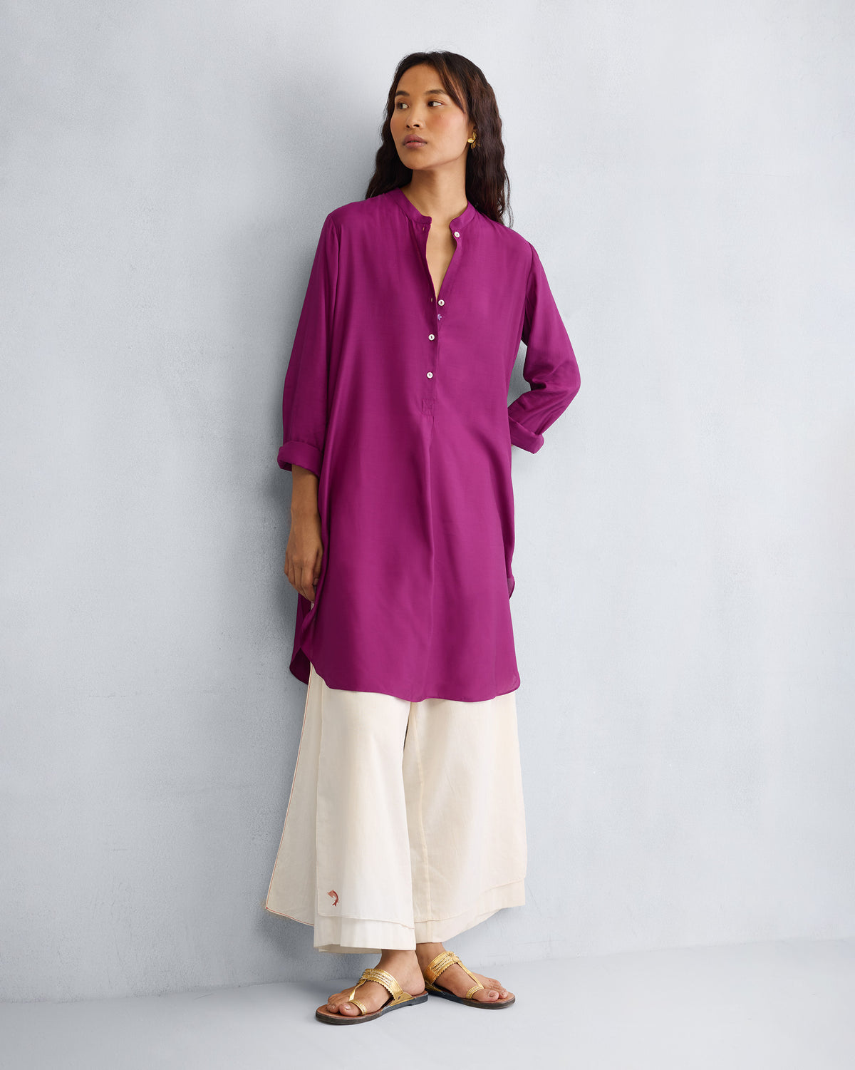 Person wearing a mulberry mid-length kurta with a mandarin collar.