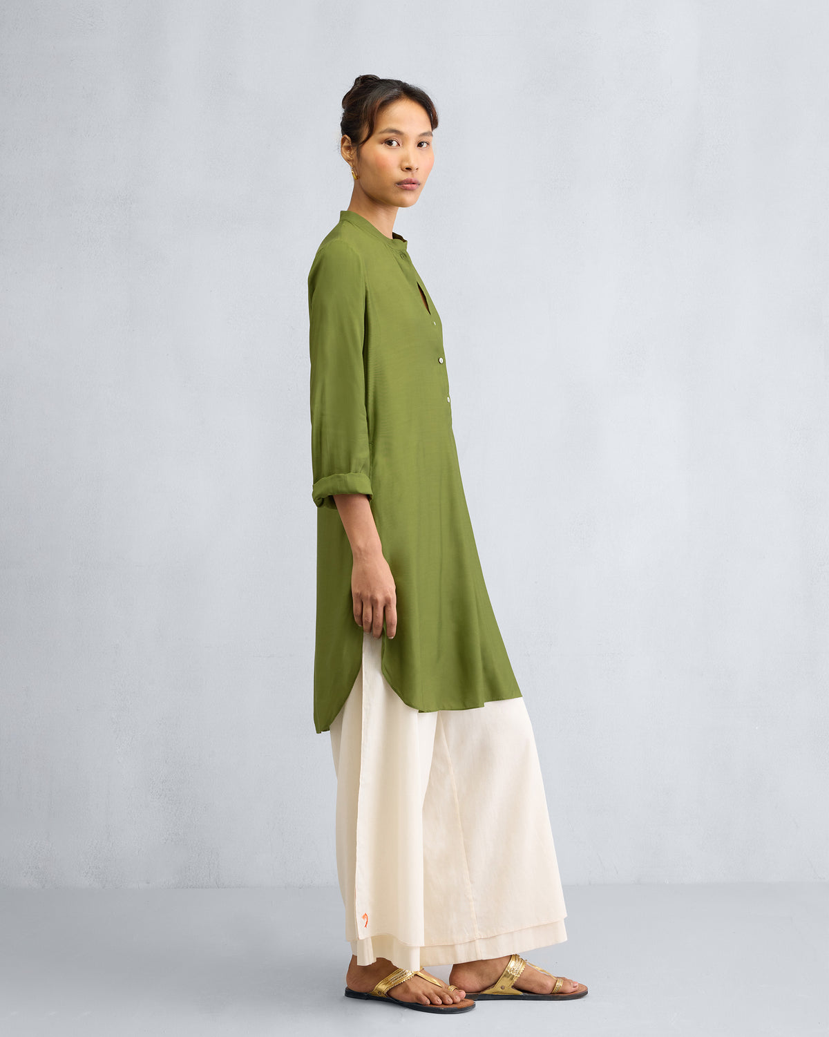 Angled view of an olive mid-length kurta with rolled sleeves.