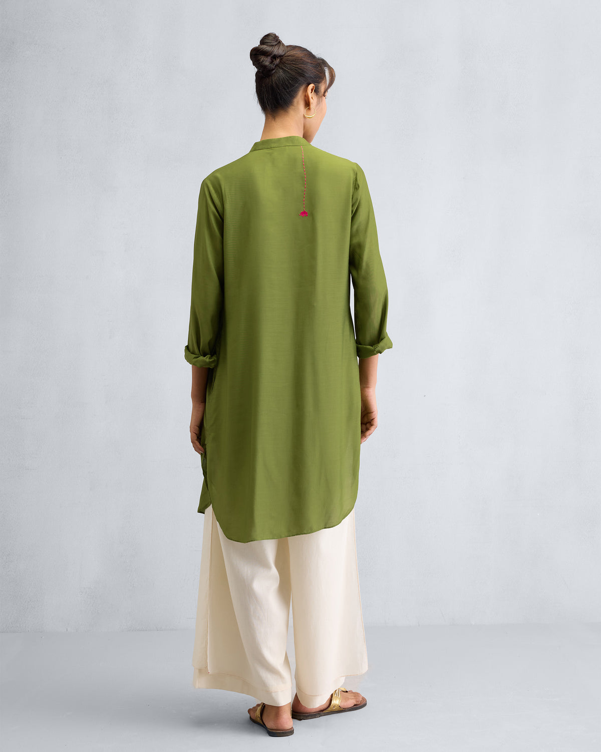 Back of an olive mid-length kurta with a small pink embroidery.