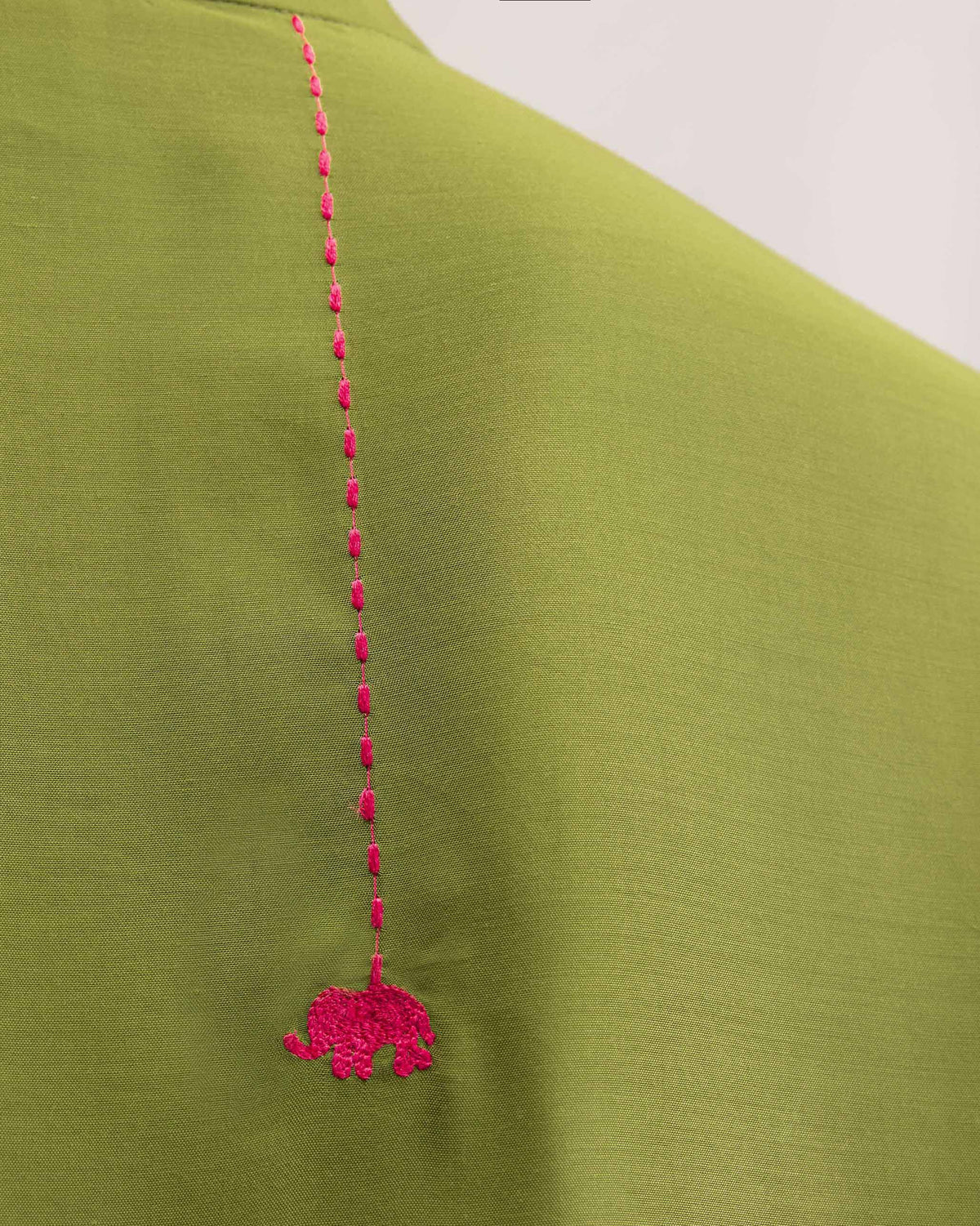 Close-up of a pink elephant embroidery on an olive mid-length kurta.