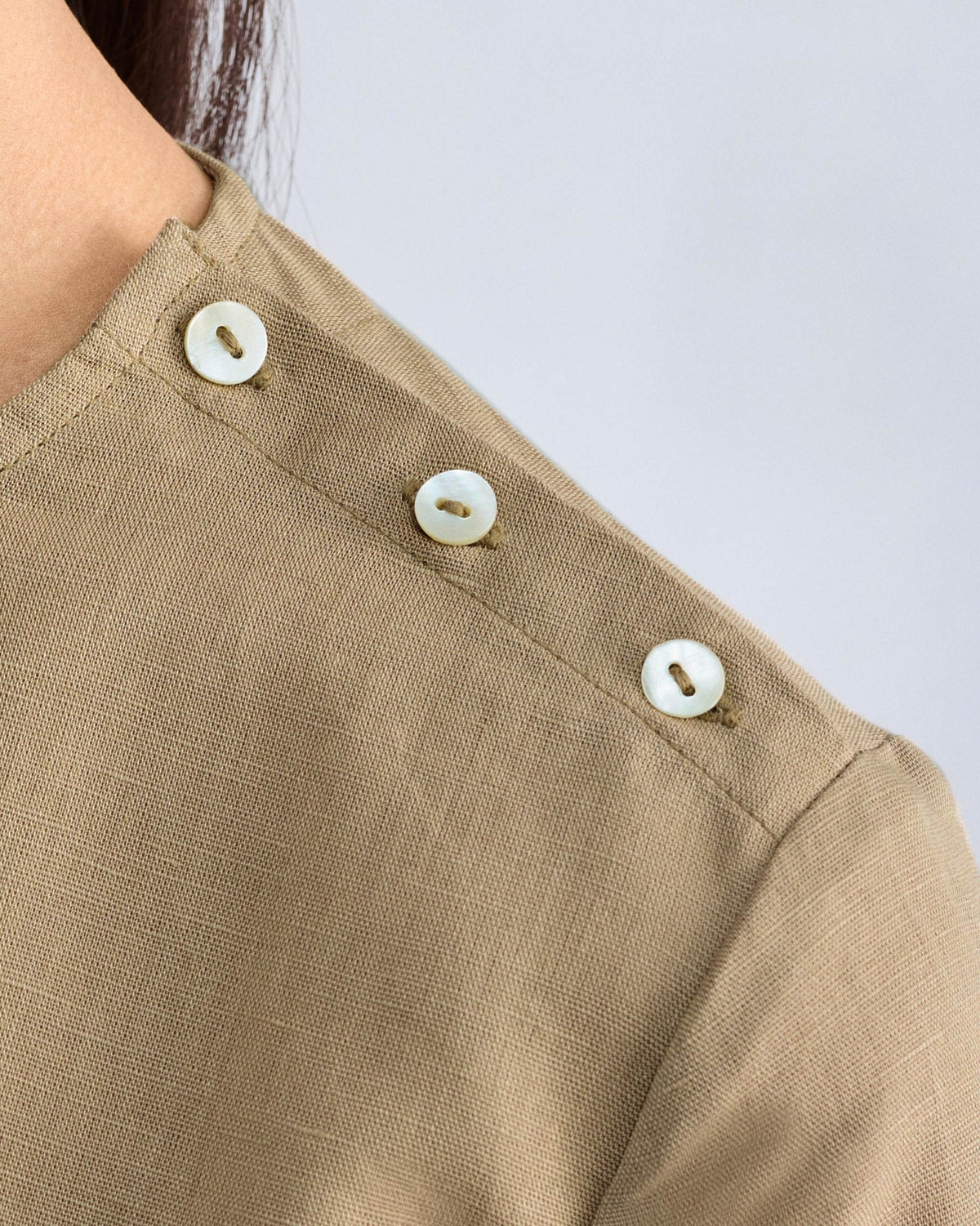 Close-up of a taupe High Slit Top showing buttons along the shoulder.