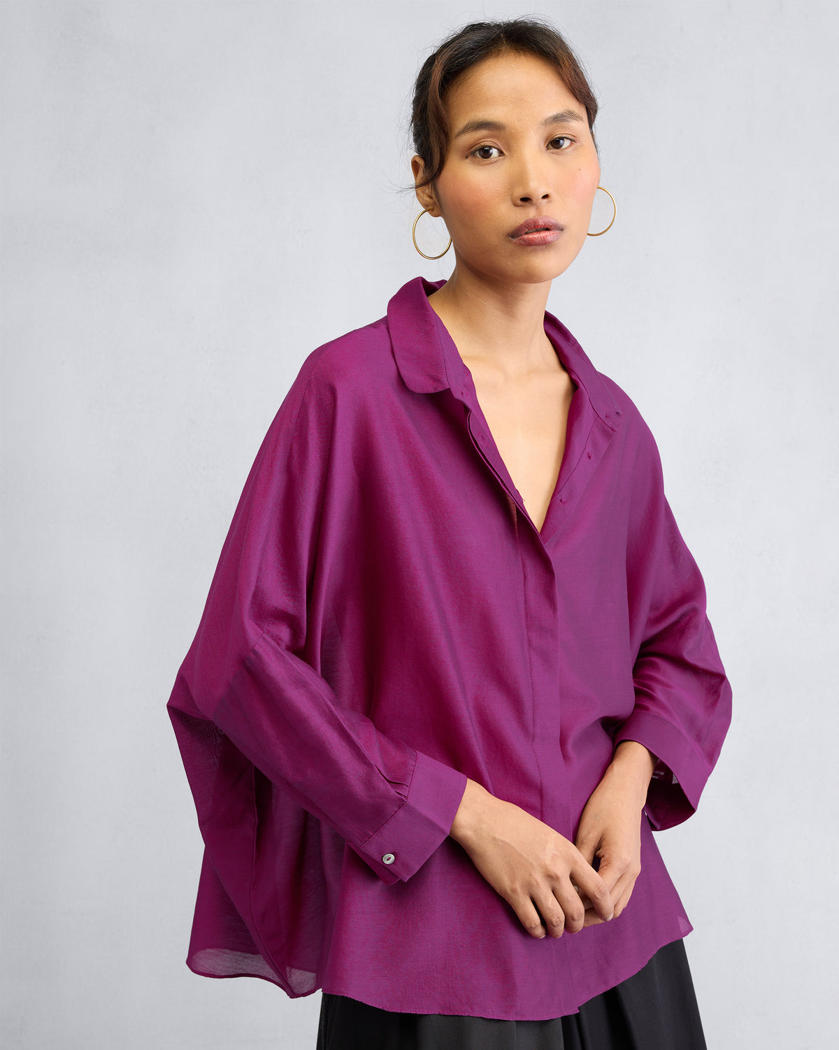 Person wearing a mulberry boxy shirt with an open collar and oversized sleeves.