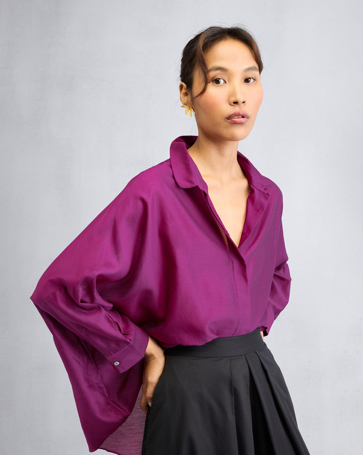 Person wearing a mulberry boxy shirt tucked into black trousers.