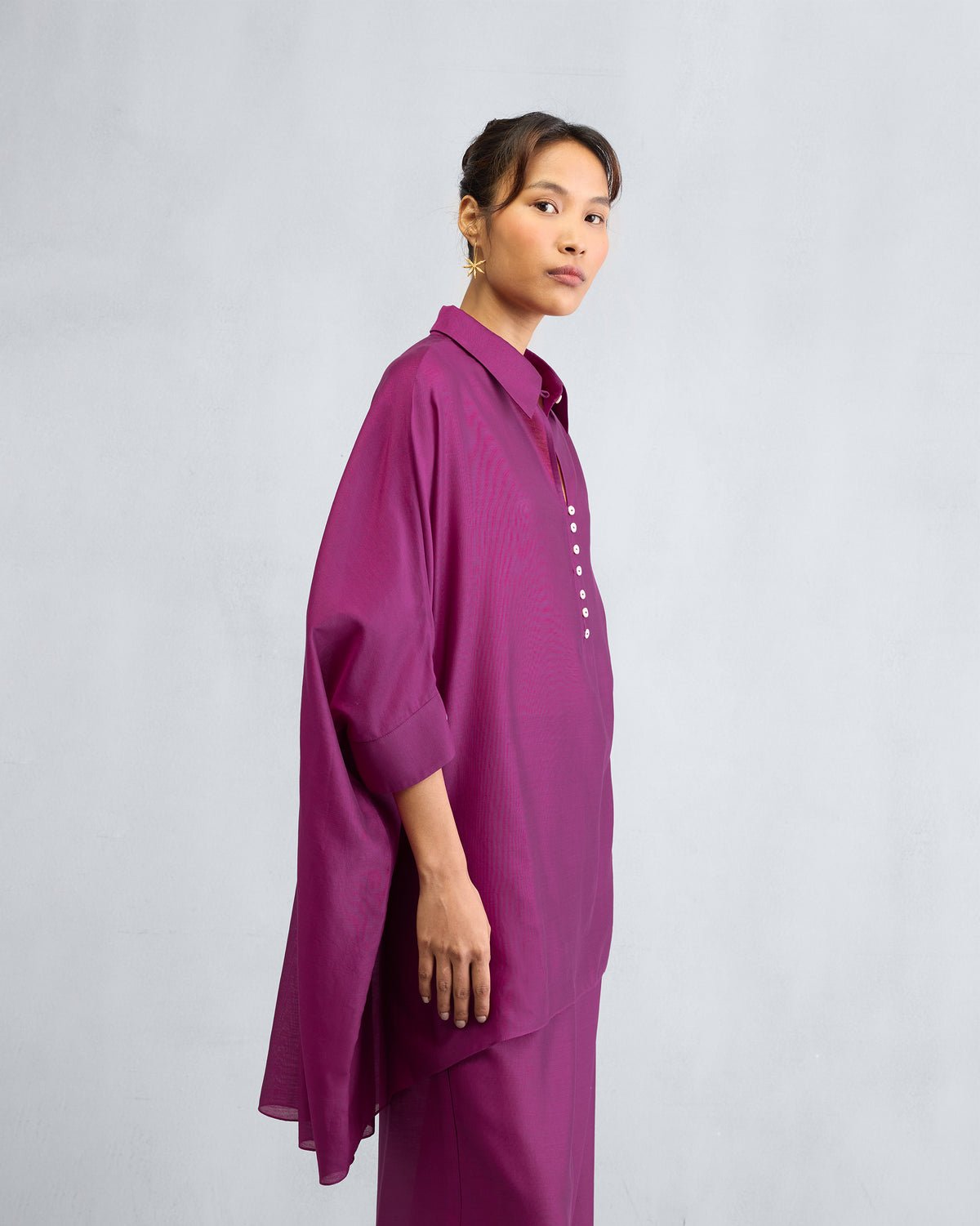 Side view of a mulberry Hala tunic showing its high-low hem and side slits.