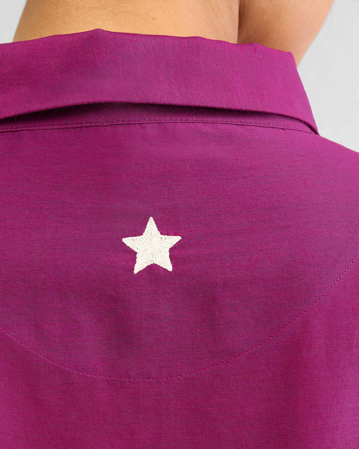 Close-up of a white embroidered star on the back of the mulberry Hala tunic.