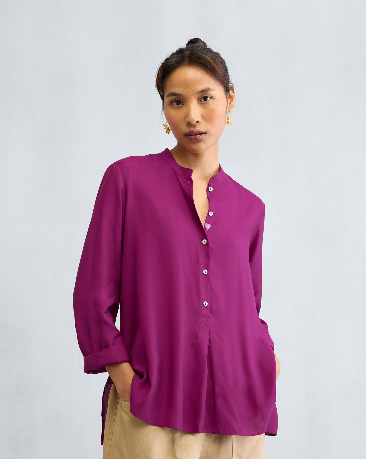 Person wearing a mulberry mandarin collar top.