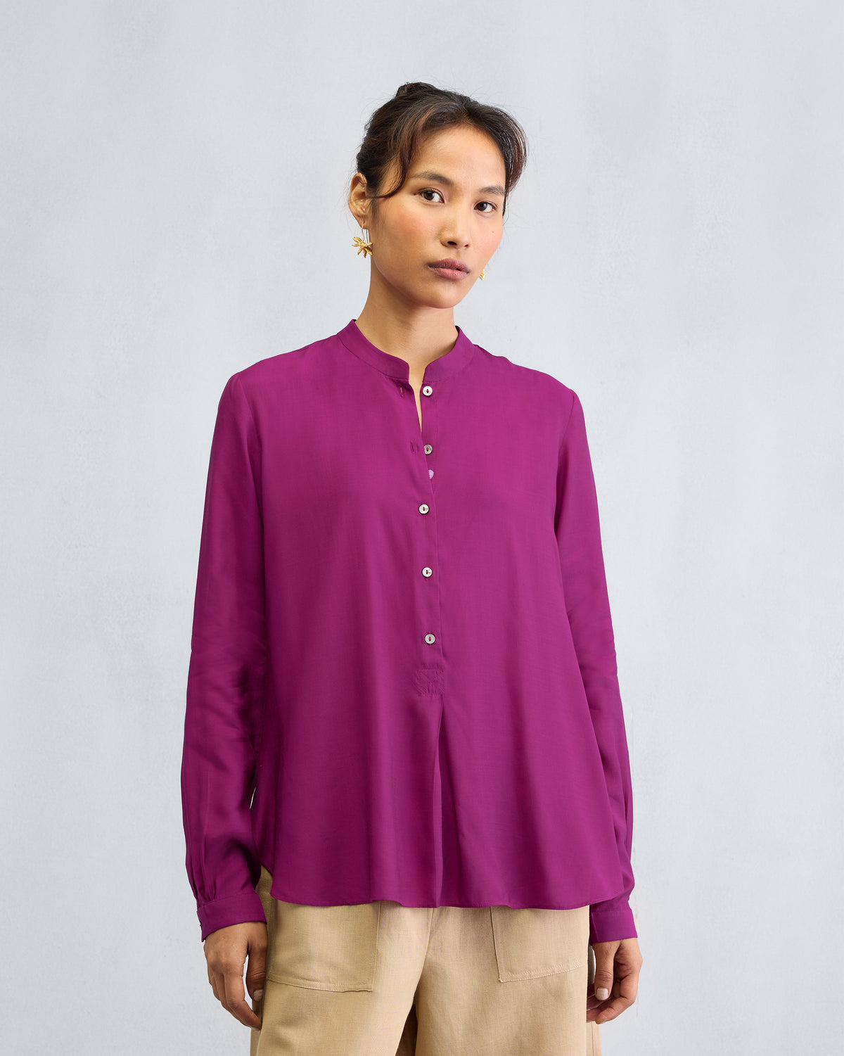 Person wearing a mulberry mandarin collar top.