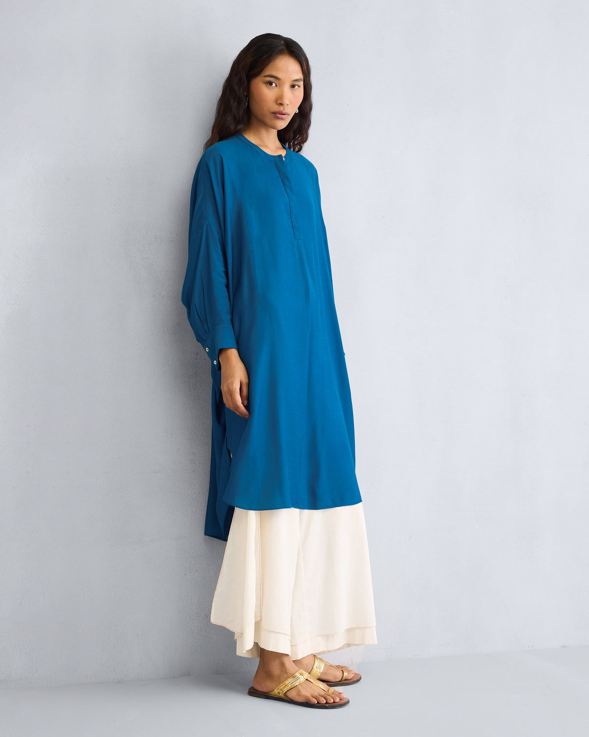 Person wearing a teal Lazy Sunday tunic with a high-low hem.