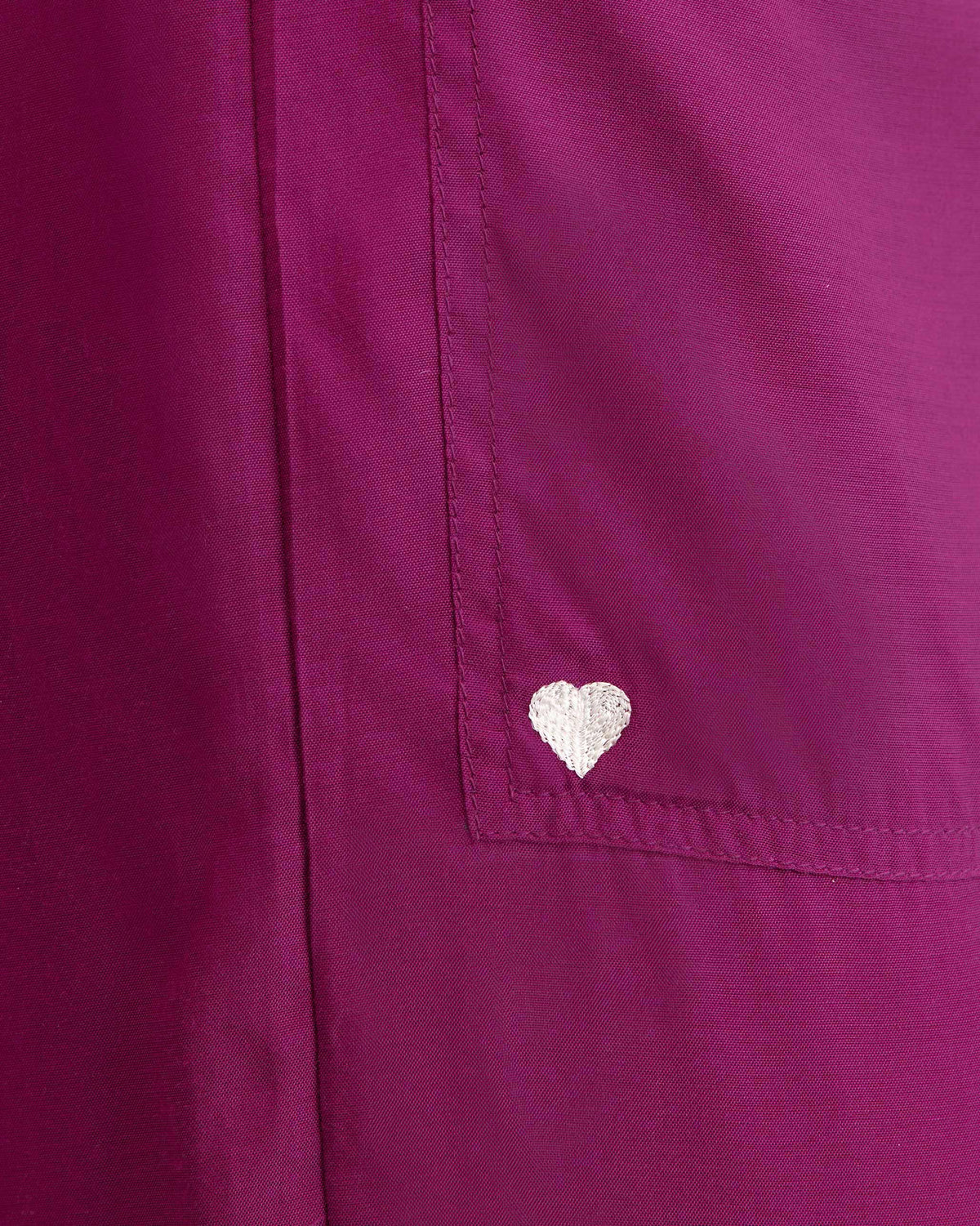 Close-up of a white heart embroidered on the pocket of mulberry Serene pants.