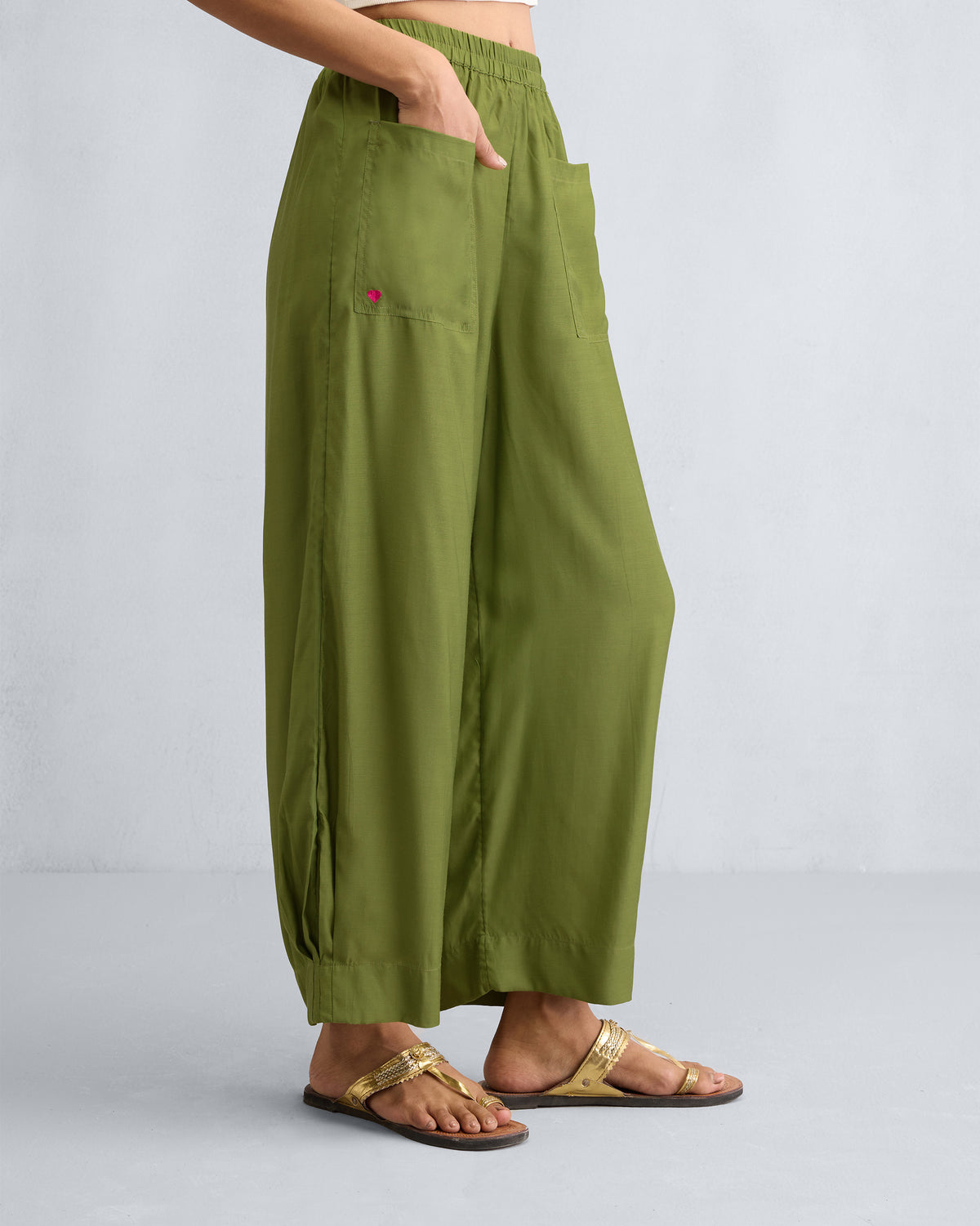 Side view of olive Serene pants with hands in the patch pockets.