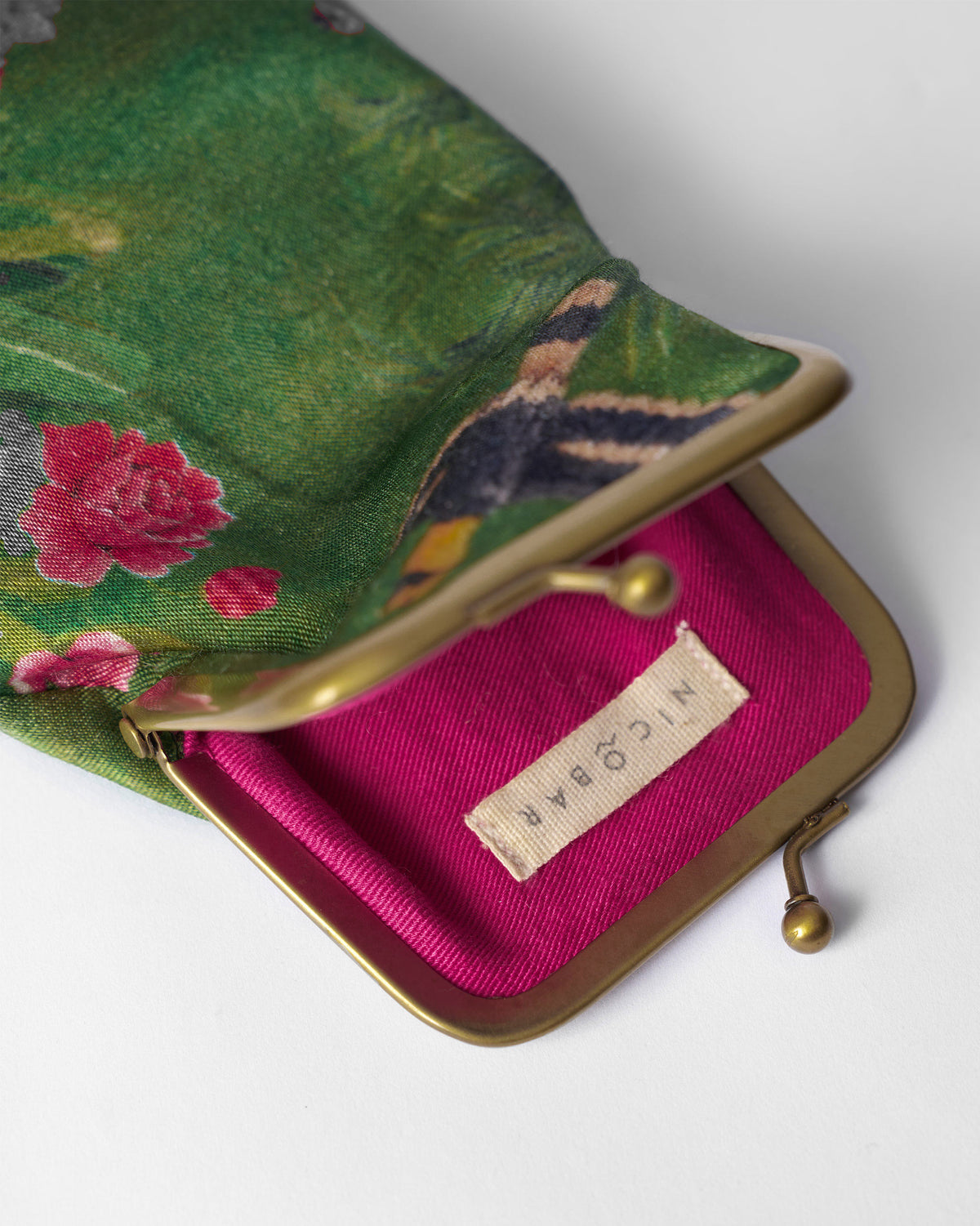 Open green Hana Spec Case revealing a fuchsia pink lining.