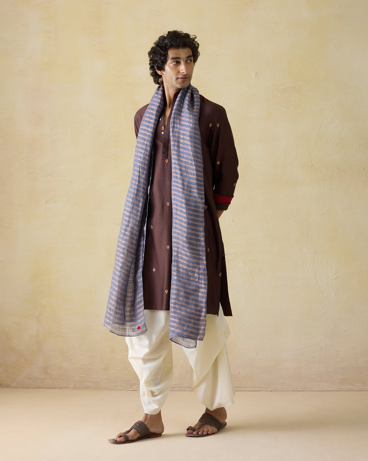 Person wearing the Firefly Scarf in grey and gold stripes draped over the shoulders.