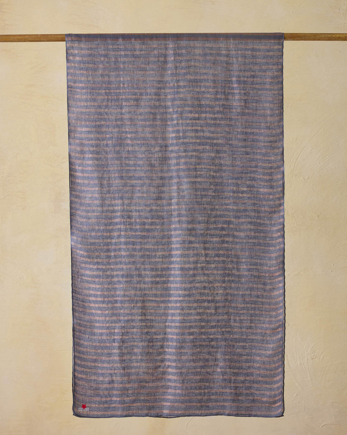 Firefly Scarf in grey and gold stripes, hung from a rod.