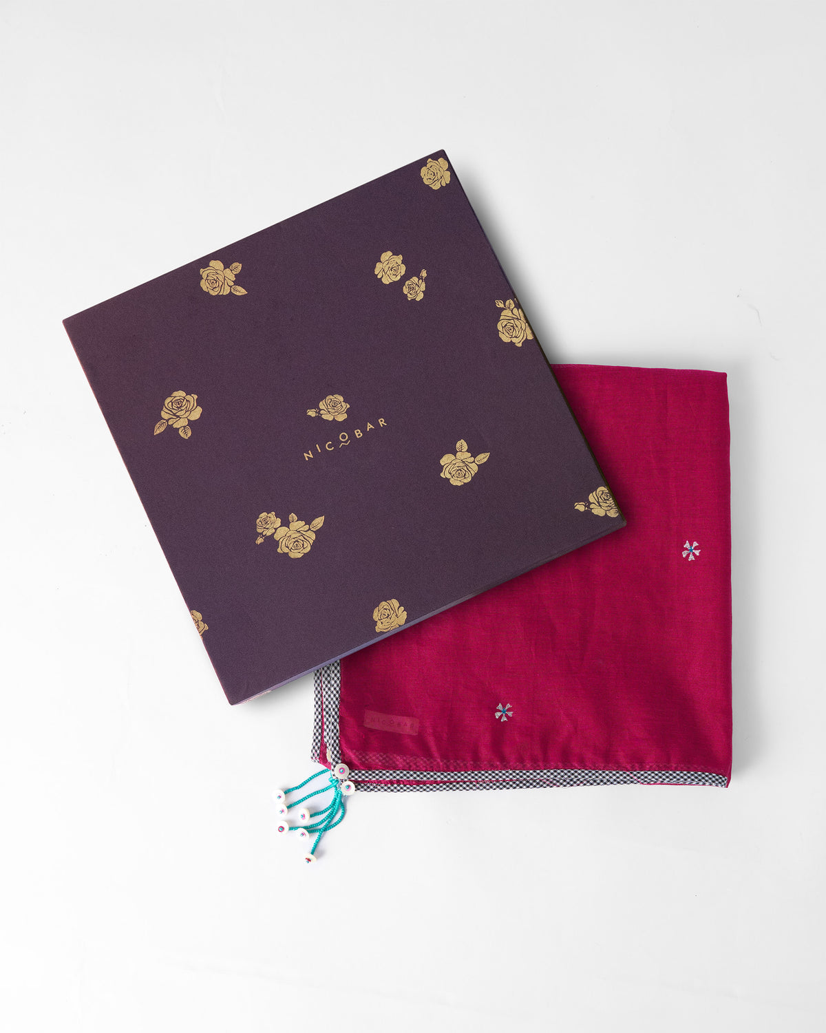 Jashn scarf folded beside its plum gift box with a gold flower print.
