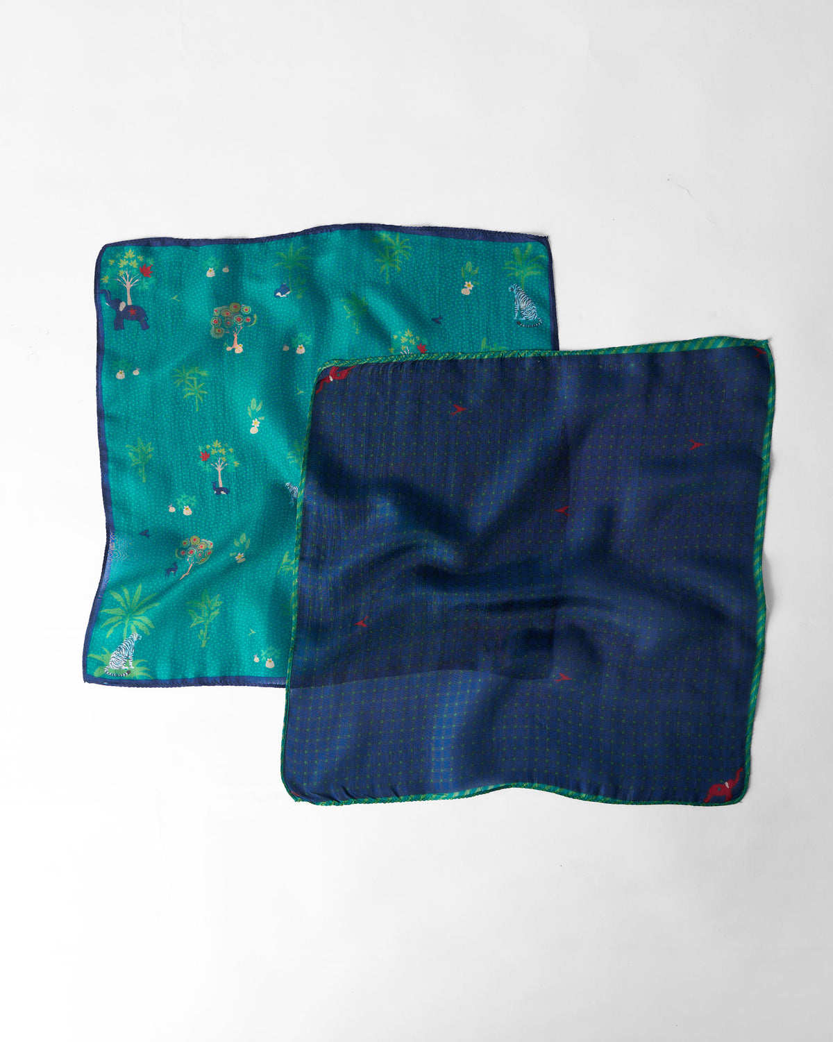 Pair of aqua and navy Firefly Pocket Squares laid flat.