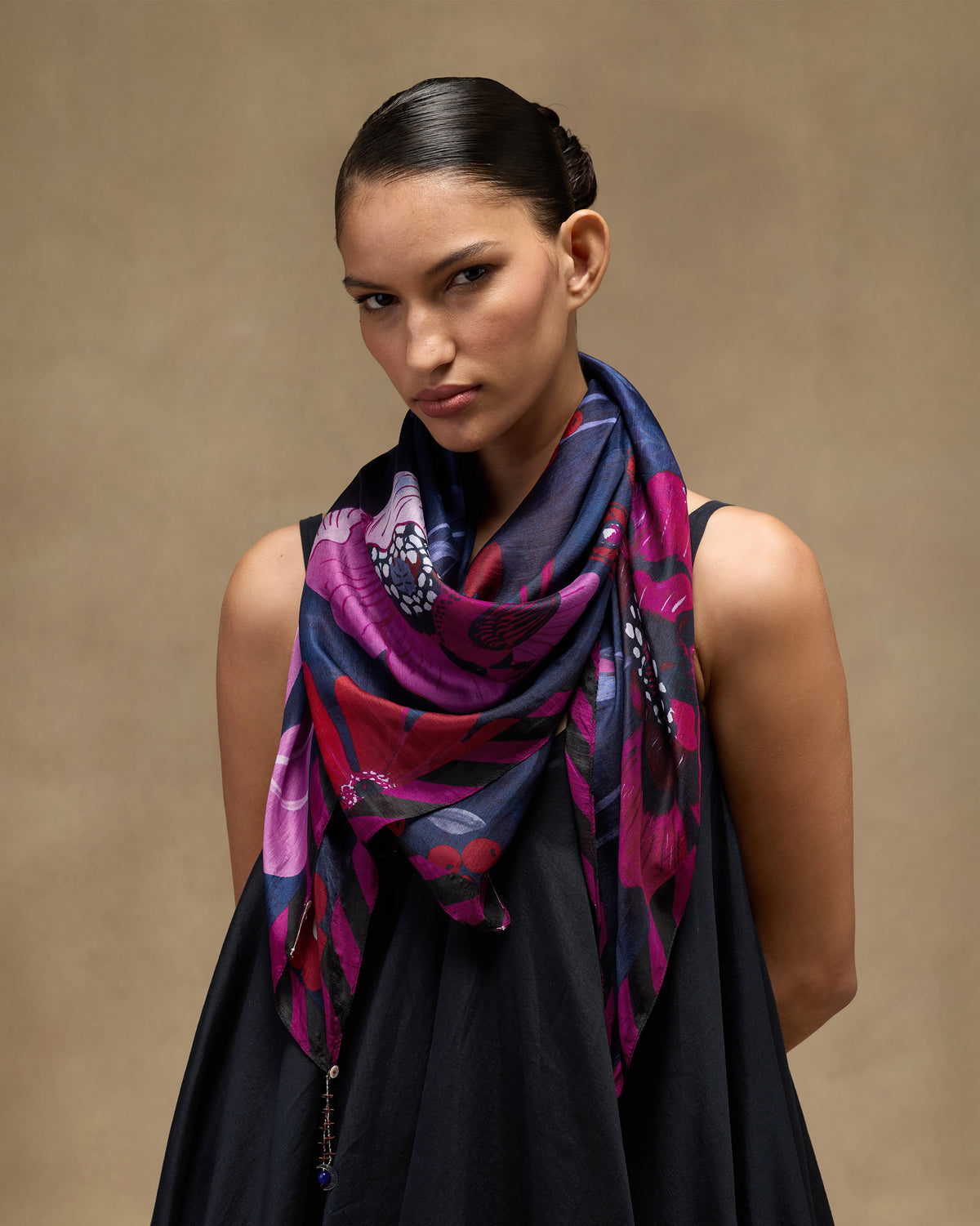 Person wearing the Garden Muse Scarf in purple and pink florals draped at the neck.