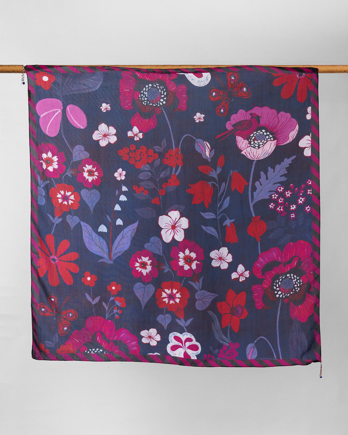 Garden Muse Scarf in navy with pink and red florals, hung from a rod.
