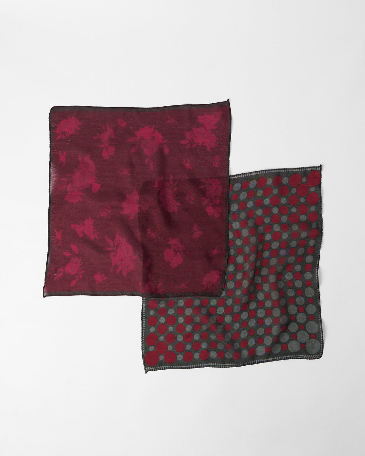 Pair of silk pocket squares in maroon floral bloom and black with red polka dots.
