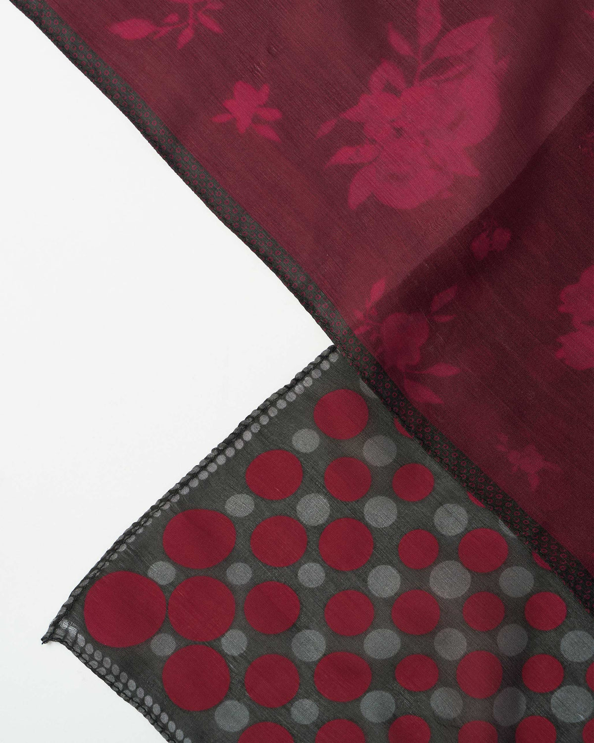 Close-up of maroon floral silk against a black pocket square with red dots.