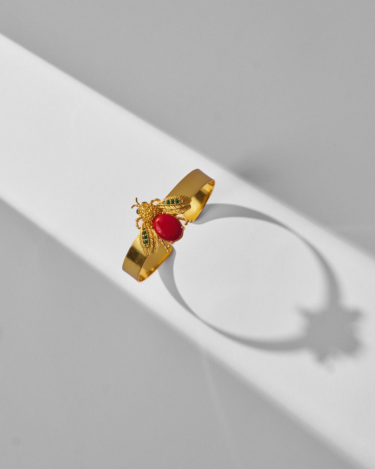 Gold Bug cuff bracelet with a red stone insect and green wing accents.