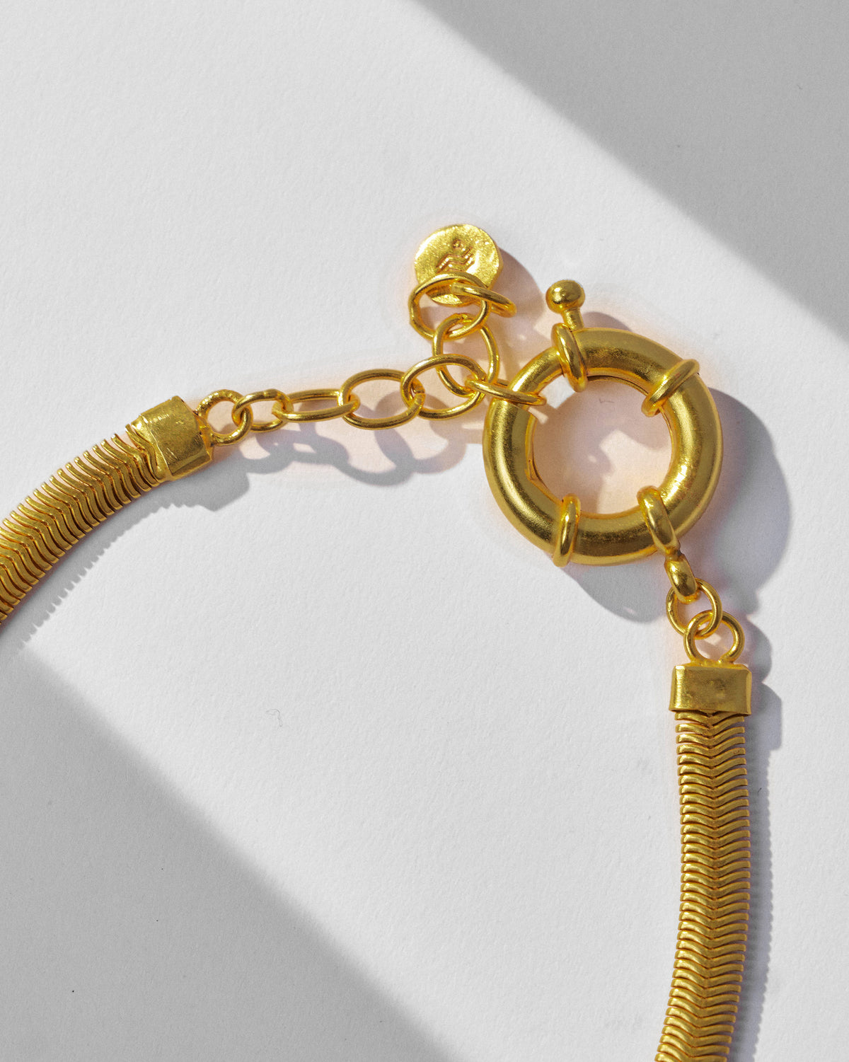 Close-up of the clasp and weave on a gold herringbone chain.