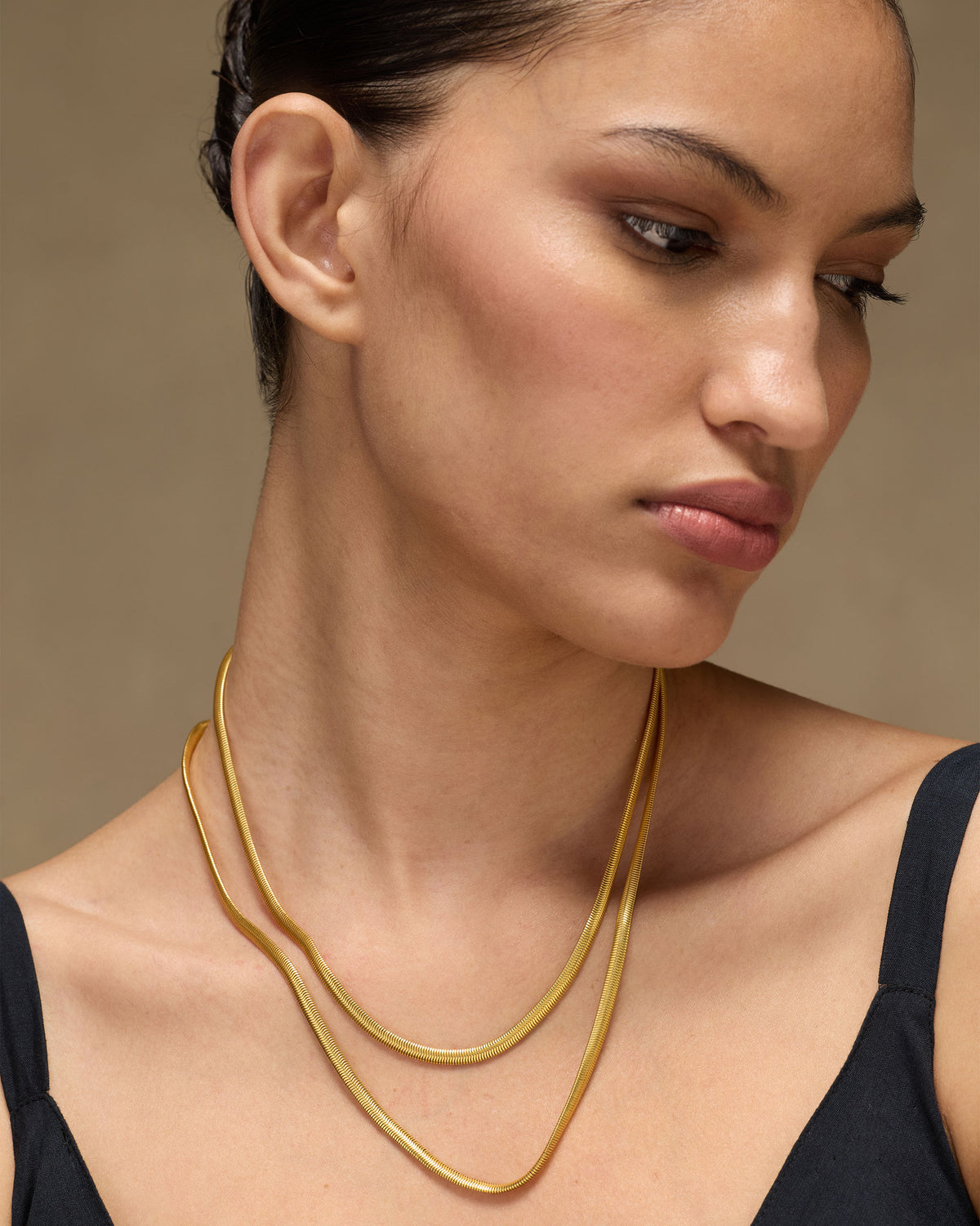 Person wearing a gold Layered Herringbone Chain in two layers.
