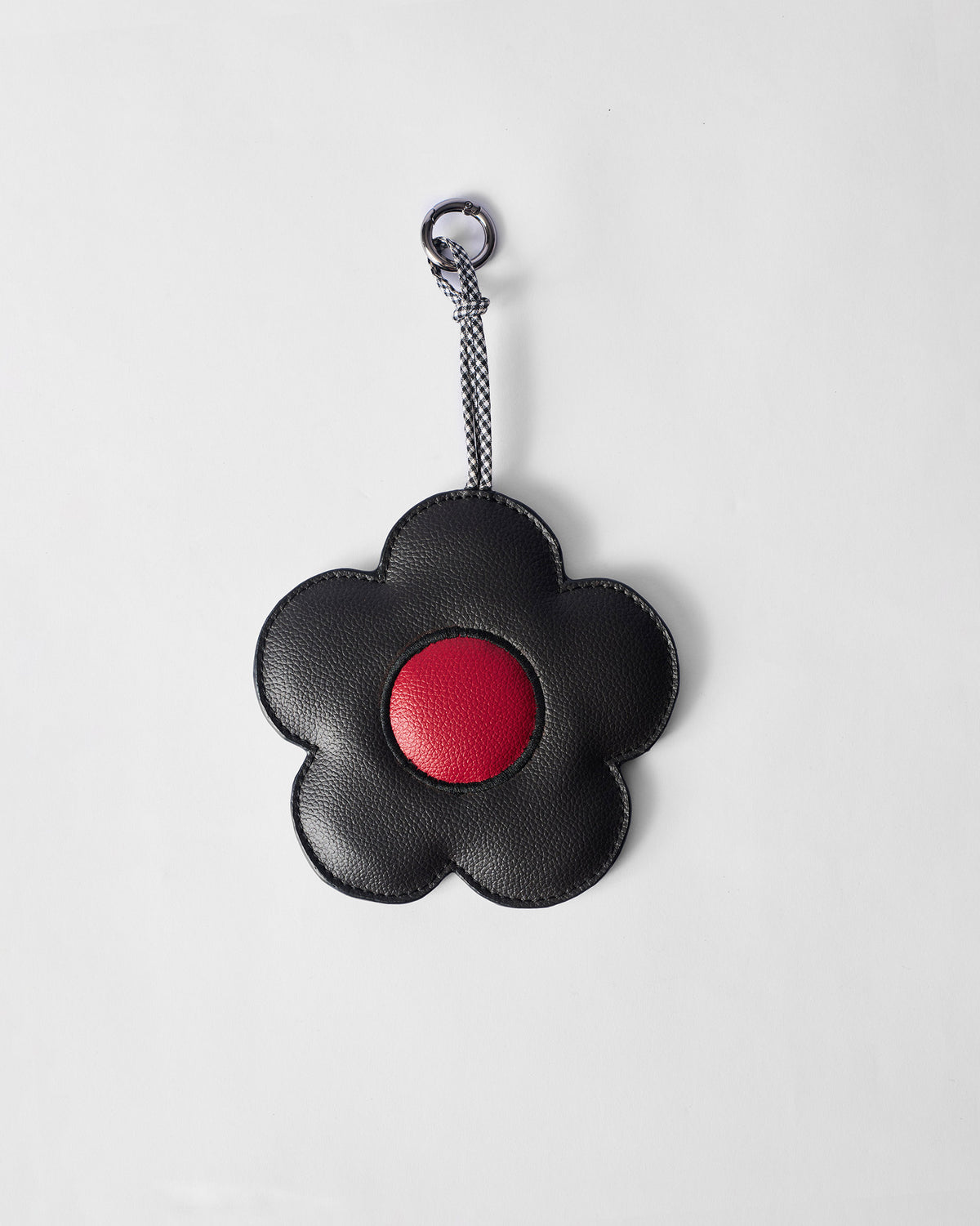 Black Flower Coin Pouch with a red centre, hanging from a braided strap.