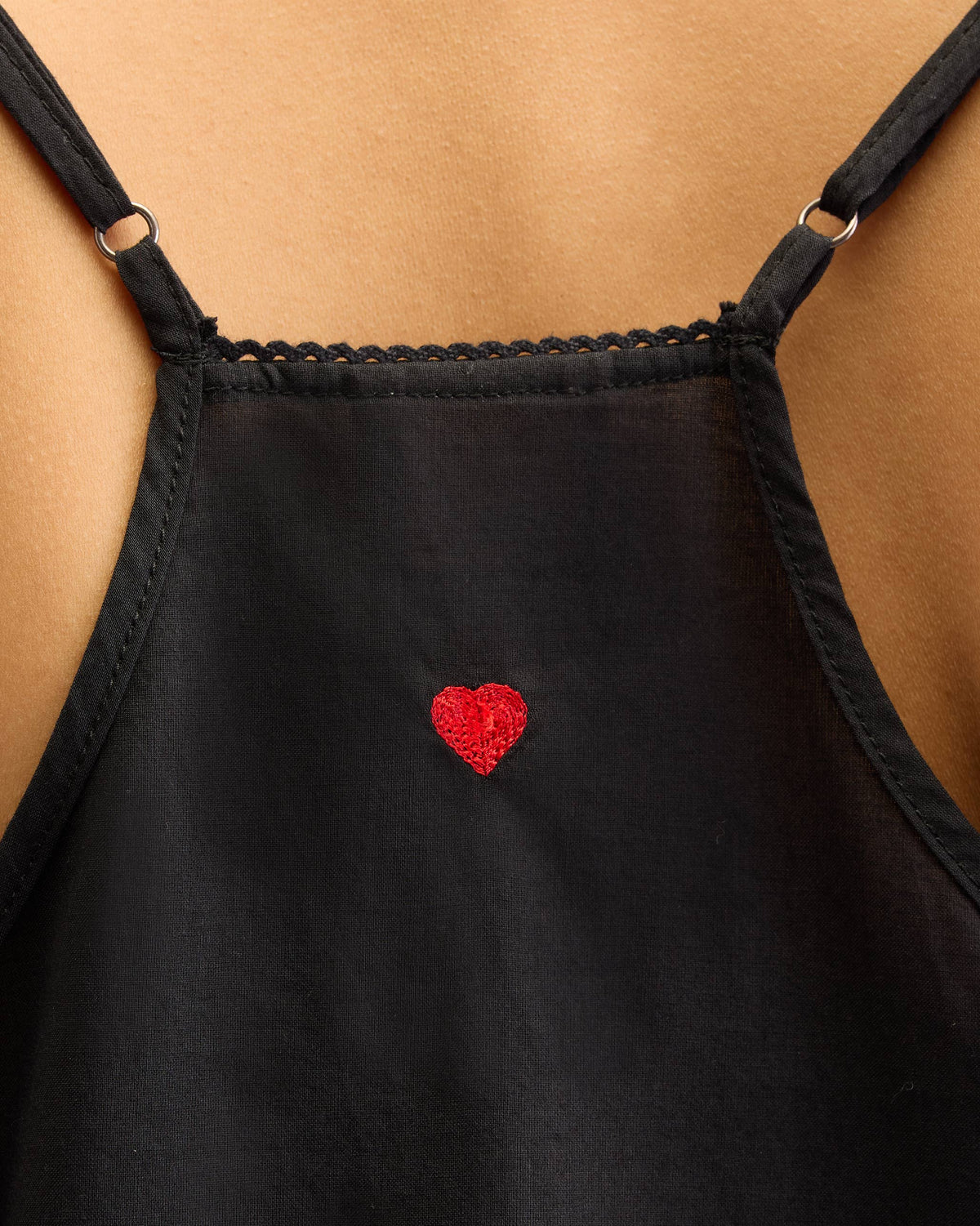Close-up of a black Afra Camisole showing a red embroidered heart.