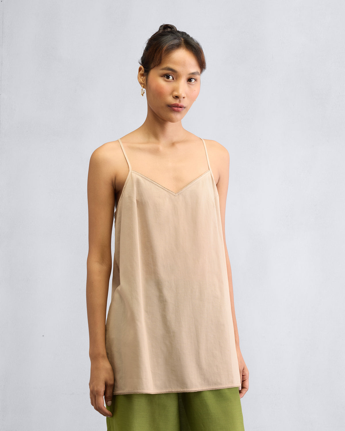 Person wearing a sand Afra Camisole with thin spaghetti straps.