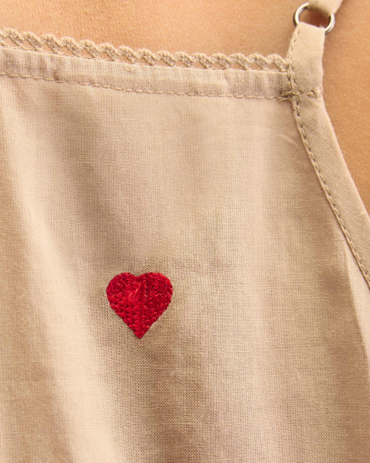 Close-up of a sand Afra Camisole showing a red embroidered heart.