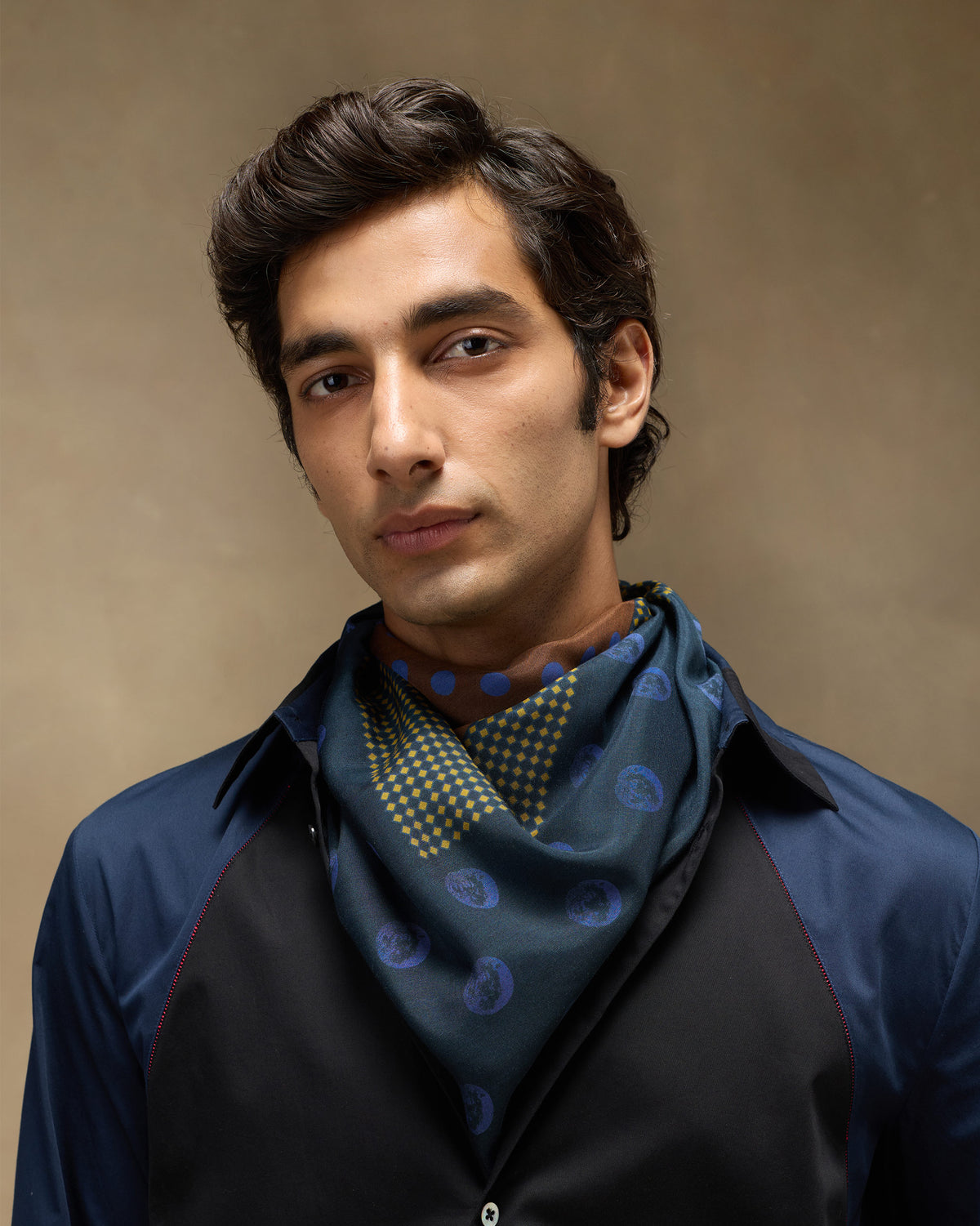 Person wearing a Rhythm Scarf in navy with blue and yellow dots.