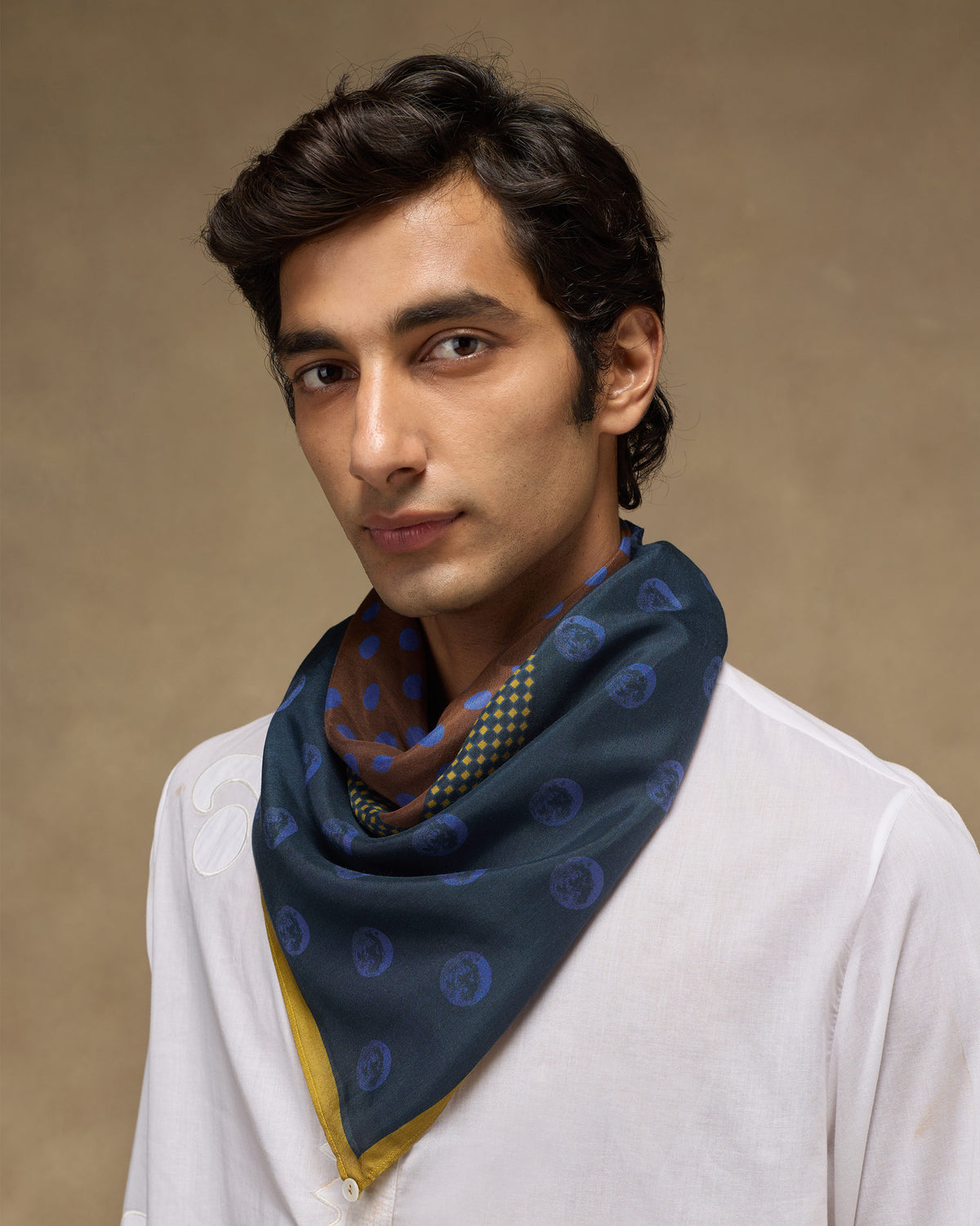 Person wearing a Rhythm Scarf in navy knotted at the neck.