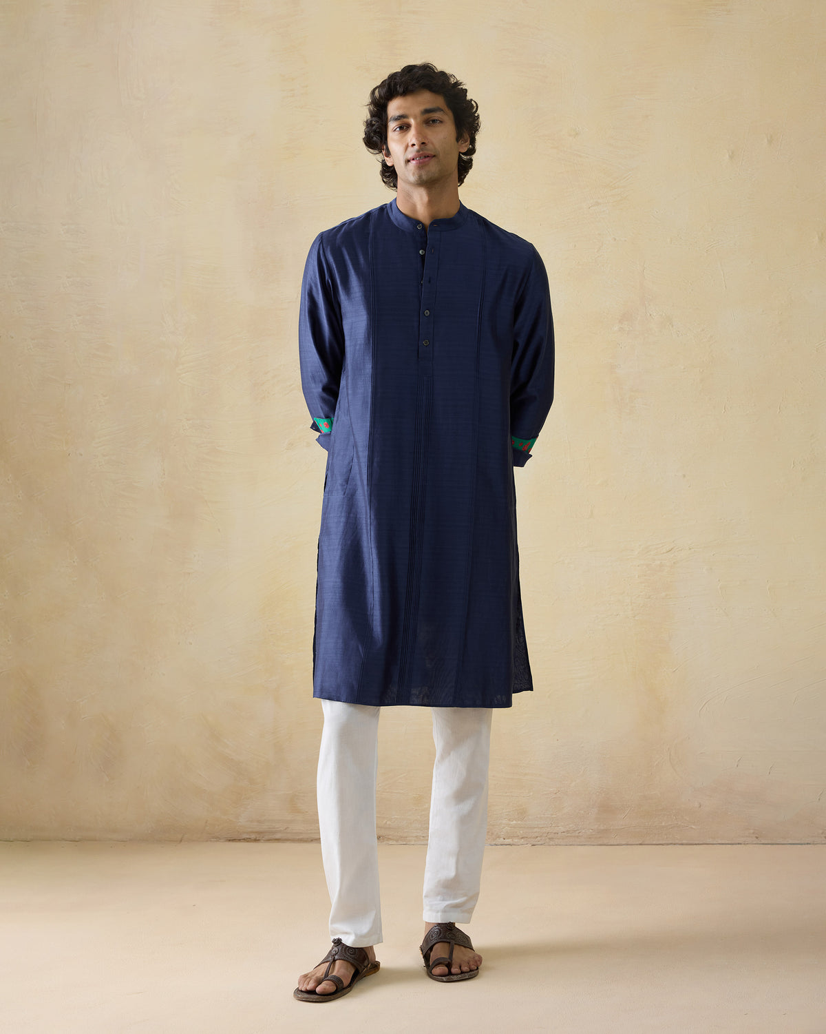 Person wearing a navy Naaz kurta with band collar and contrast cuff trim.