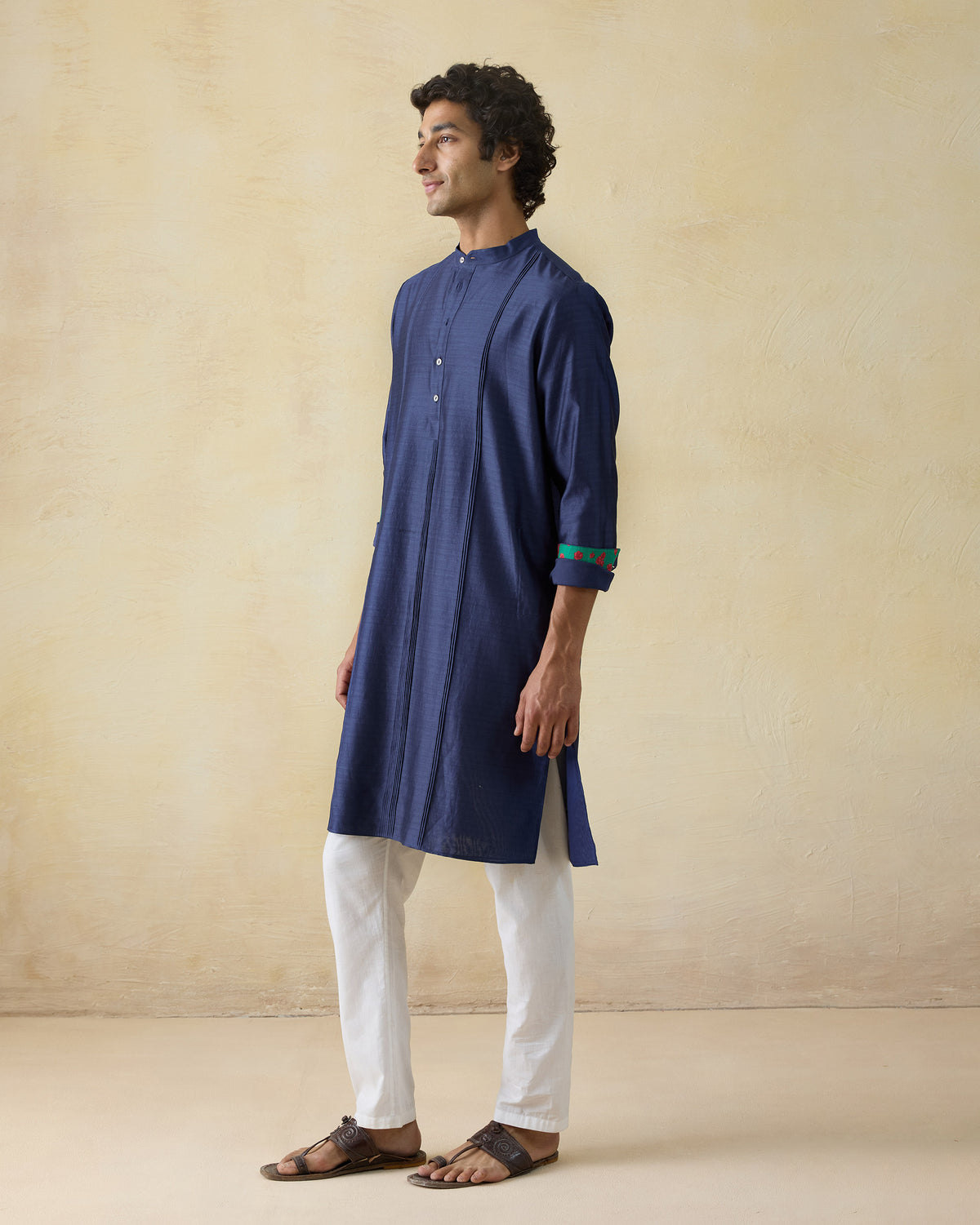 Side view of a navy Naaz kurta with contrasting cuff lining.