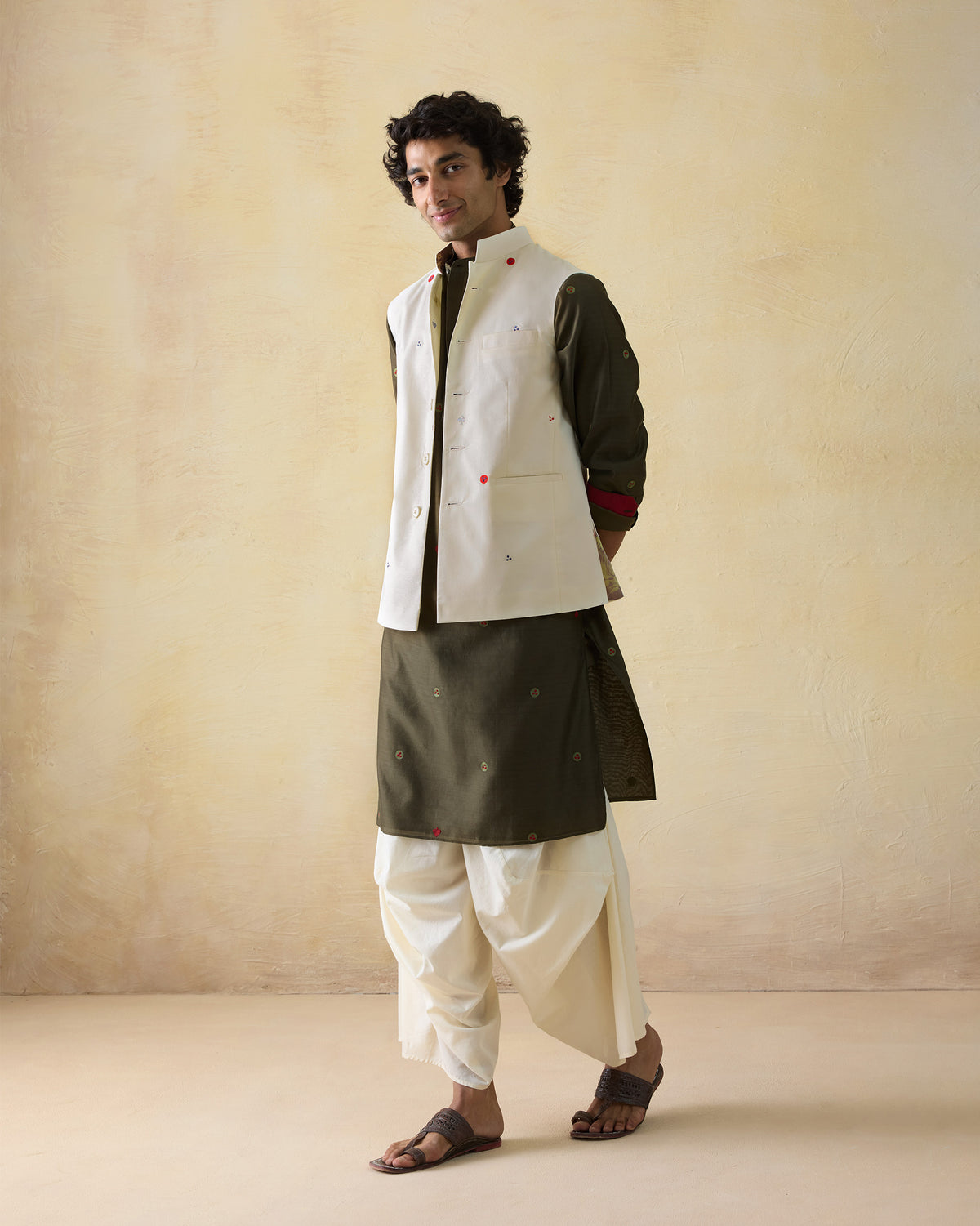 Olive green Neckband Kurta worn under a cream embroidered Nehru jacket.