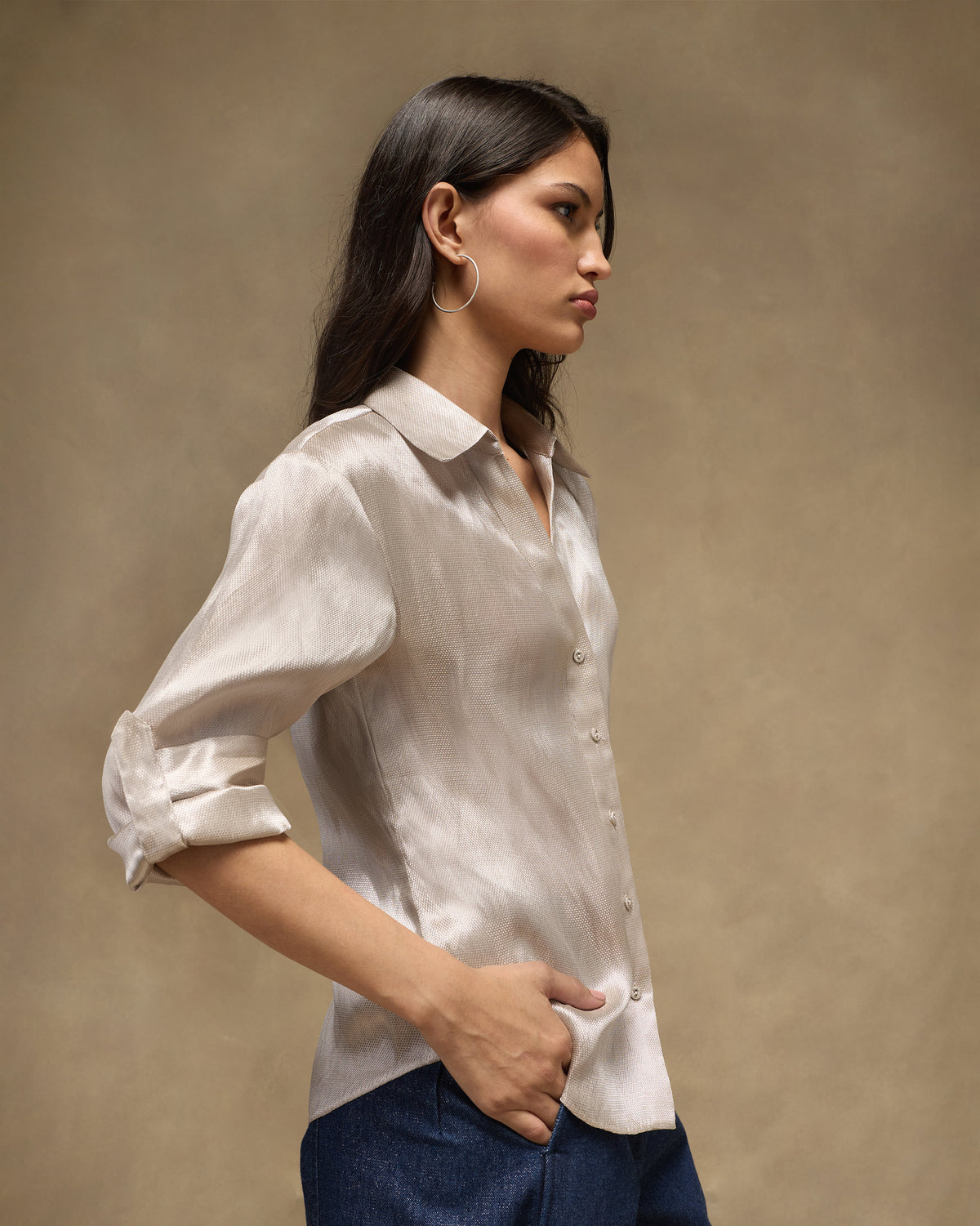Side view of a silver tissue organza shirt with rolled sleeves.