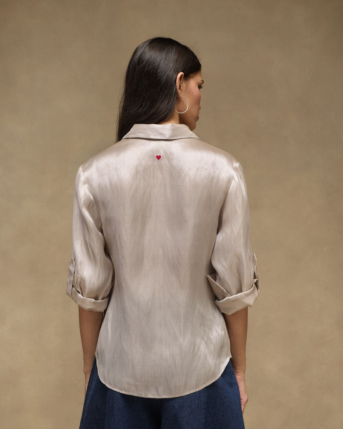 Back of a silver tissue organza shirt with a red embroidered heart.