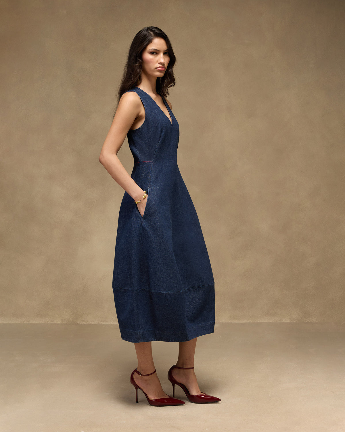 Side view of a navy denim Sway dress showing the midi A-line length.