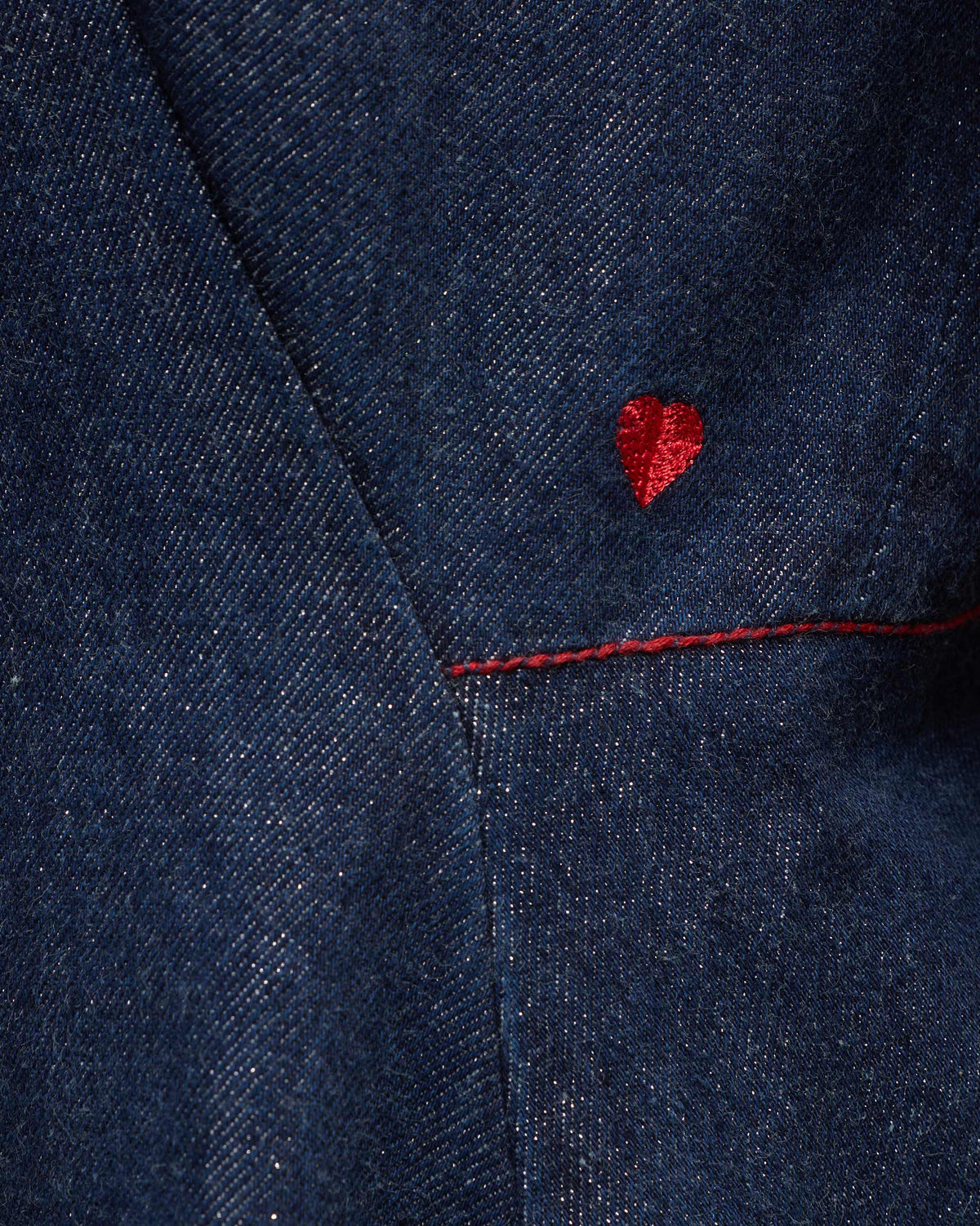 Close-up of a red heart embroidery on a navy denim Sway dress.
