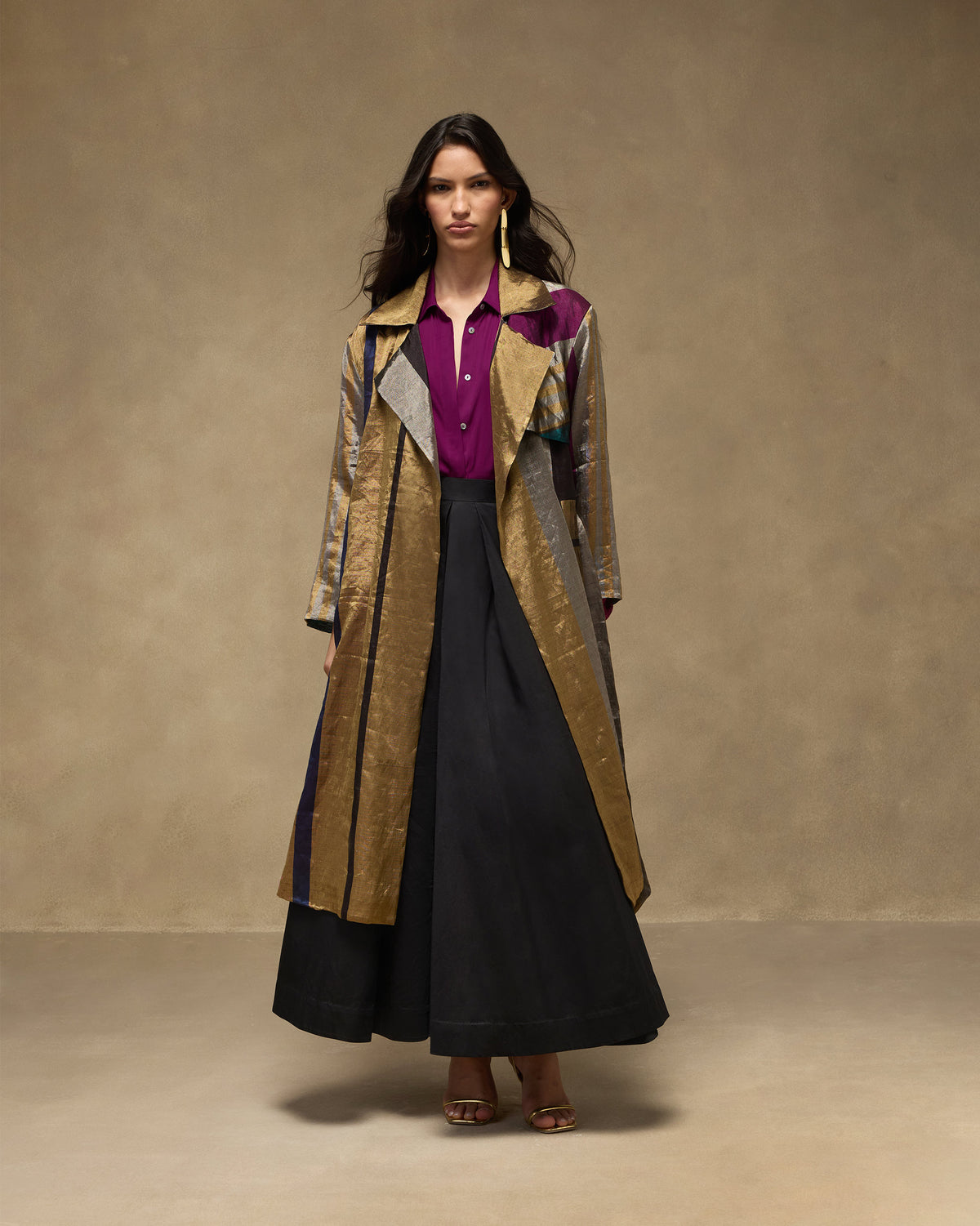 Person wearing a long multicolour metallic trench coat.