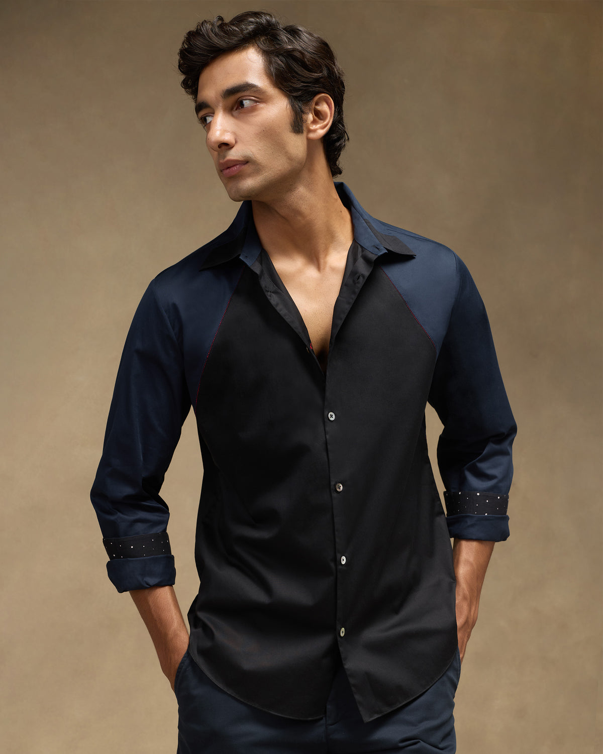 Person wearing a black-and-navy Moonrise shirt with rolled cuffs.