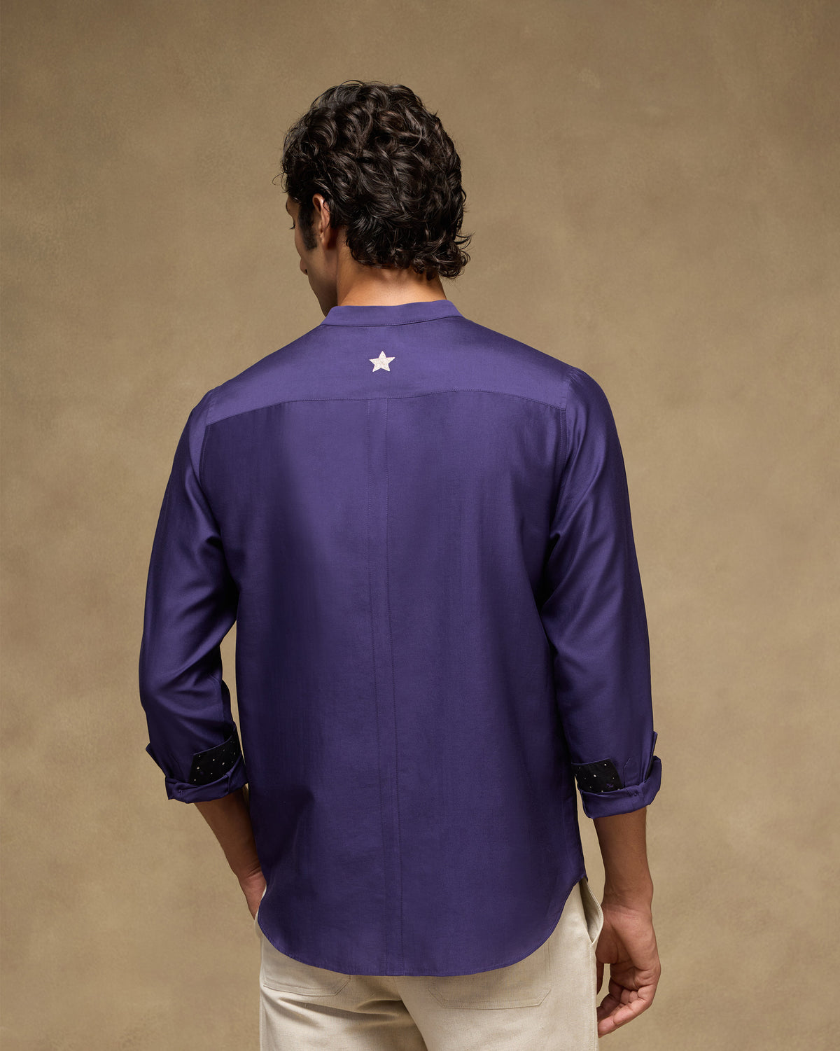 Back of a deep purple Sundown Shirt with a silver star on the yoke.