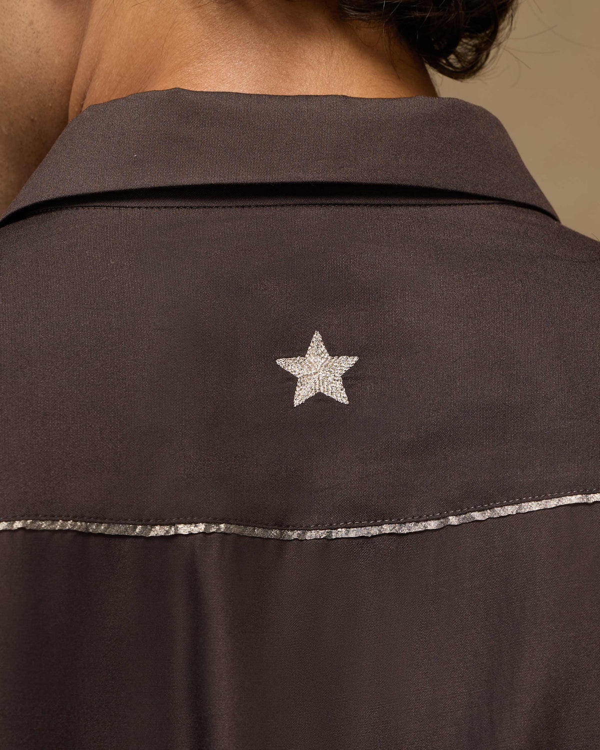 Close-up of the Afterhours shirt back showing a cream embroidered star.