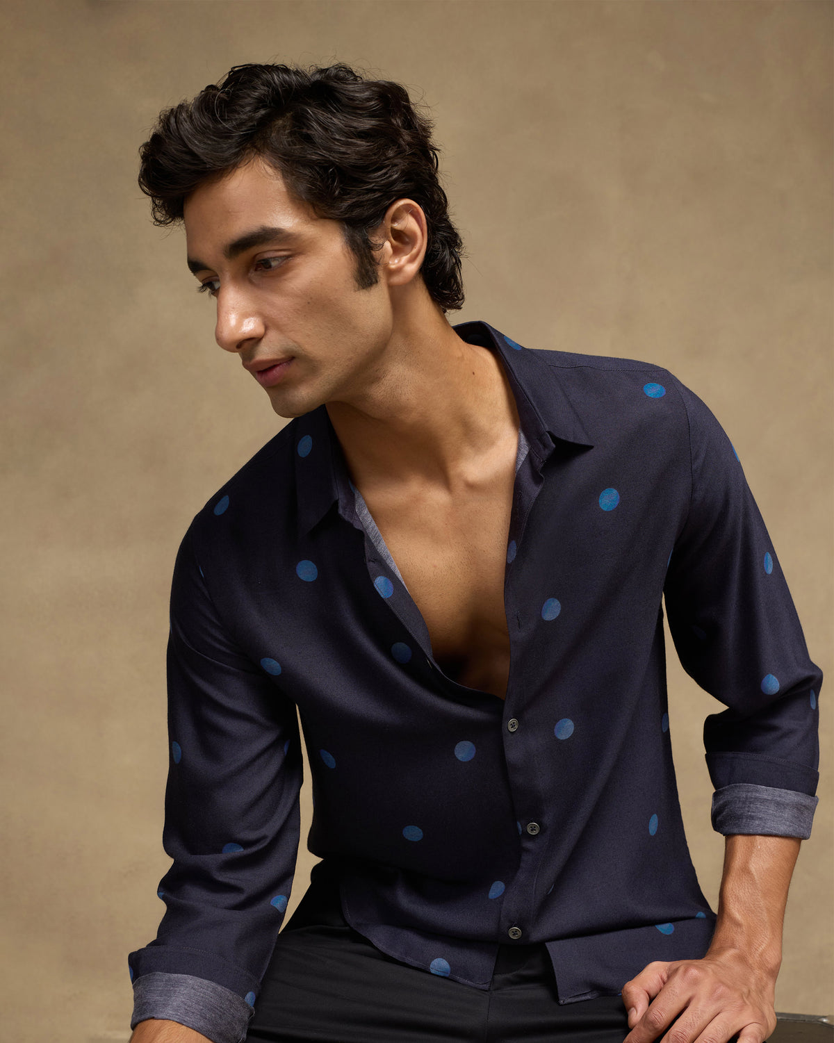 Person wearing a dark navy Daze shirt with a blue dot print.