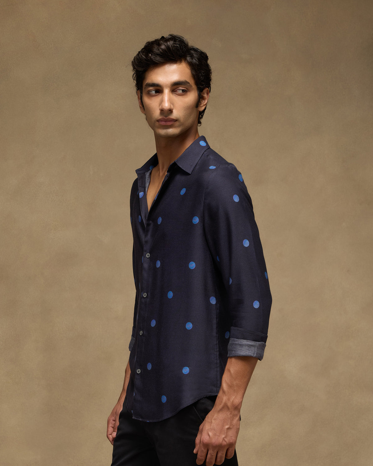 Side profile of a dark navy Daze shirt with a blue dot print.