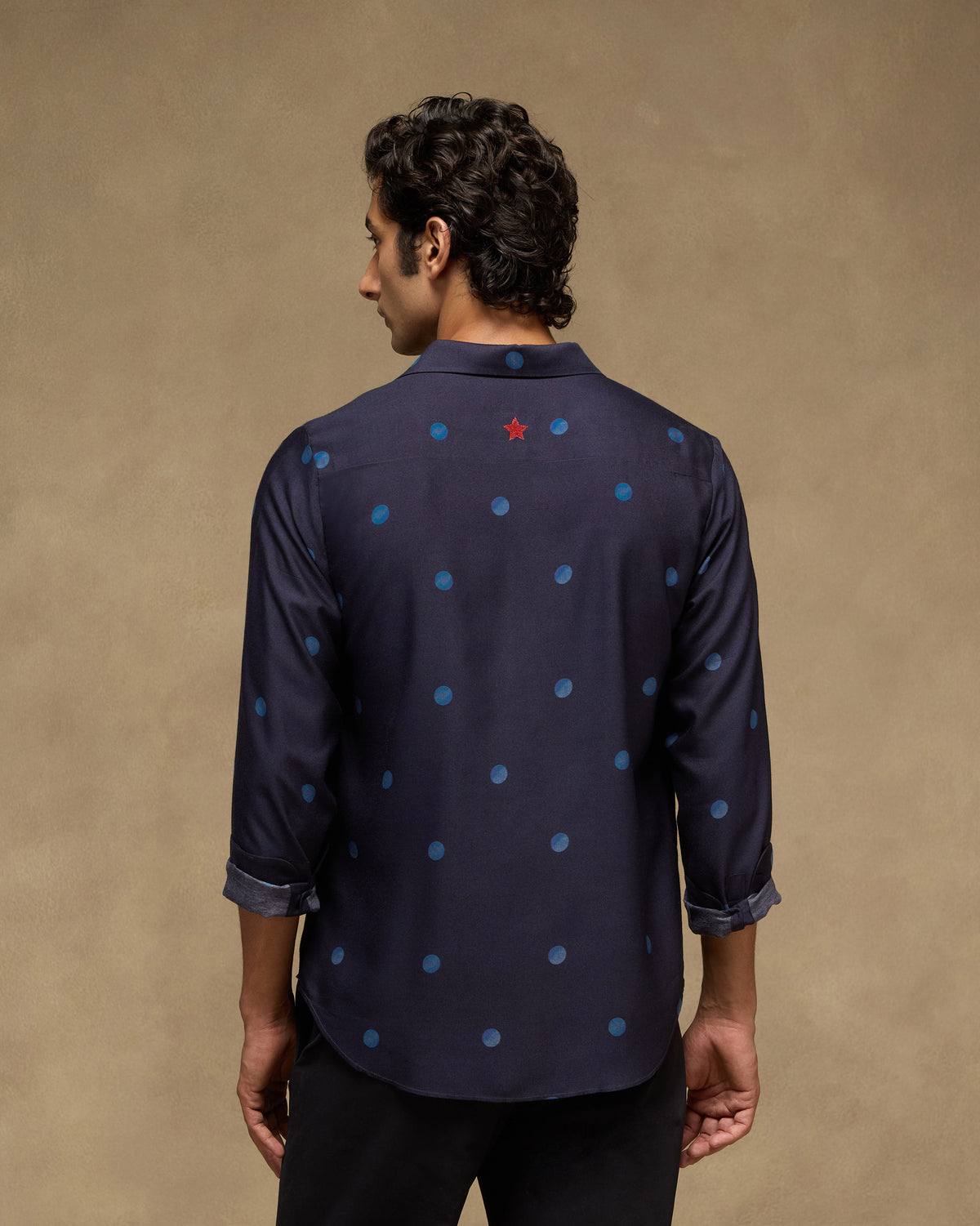 Back of a dark navy Daze shirt with a red star below the collar.