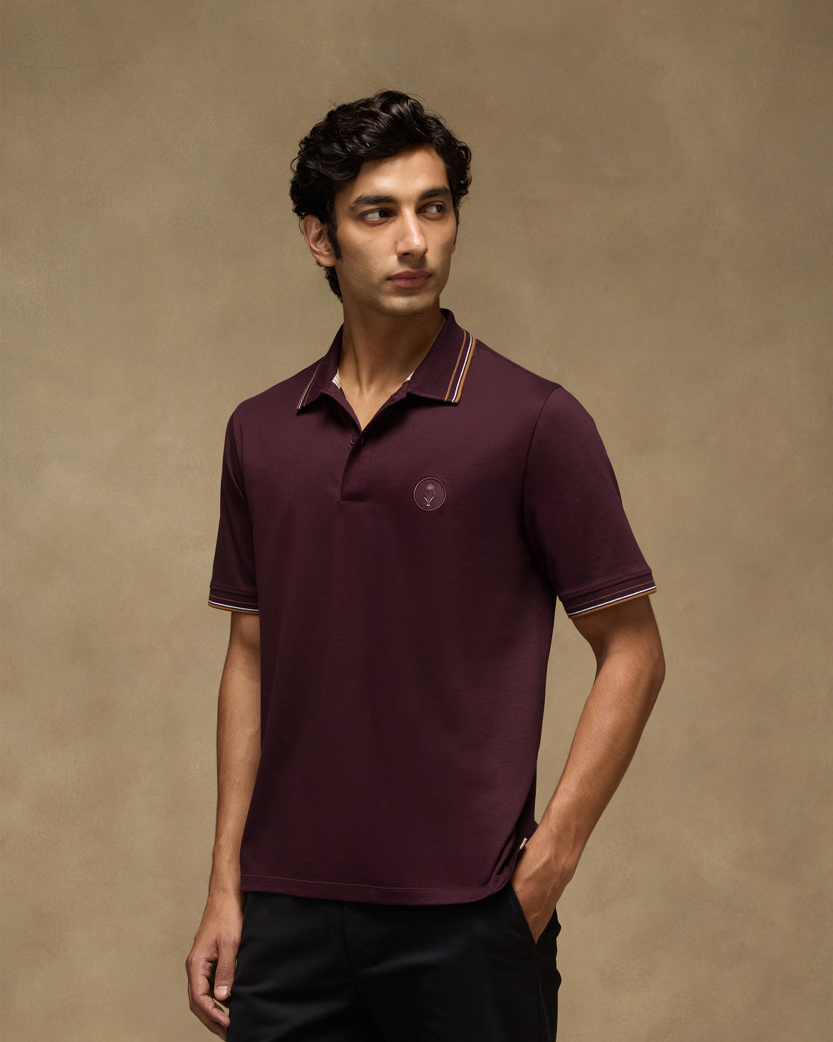 Person wearing a maroon Stag Polo with striped collar and cuff tipping.