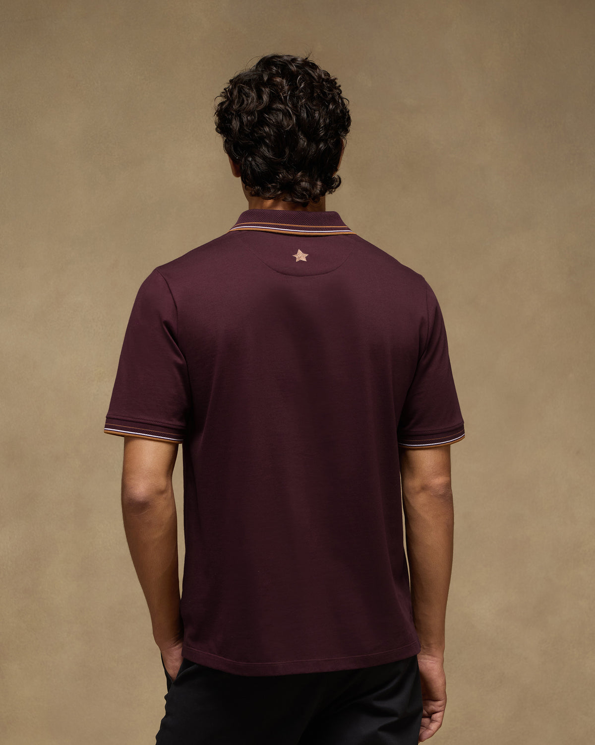 Back of a maroon Stag Polo with a star below the collar.