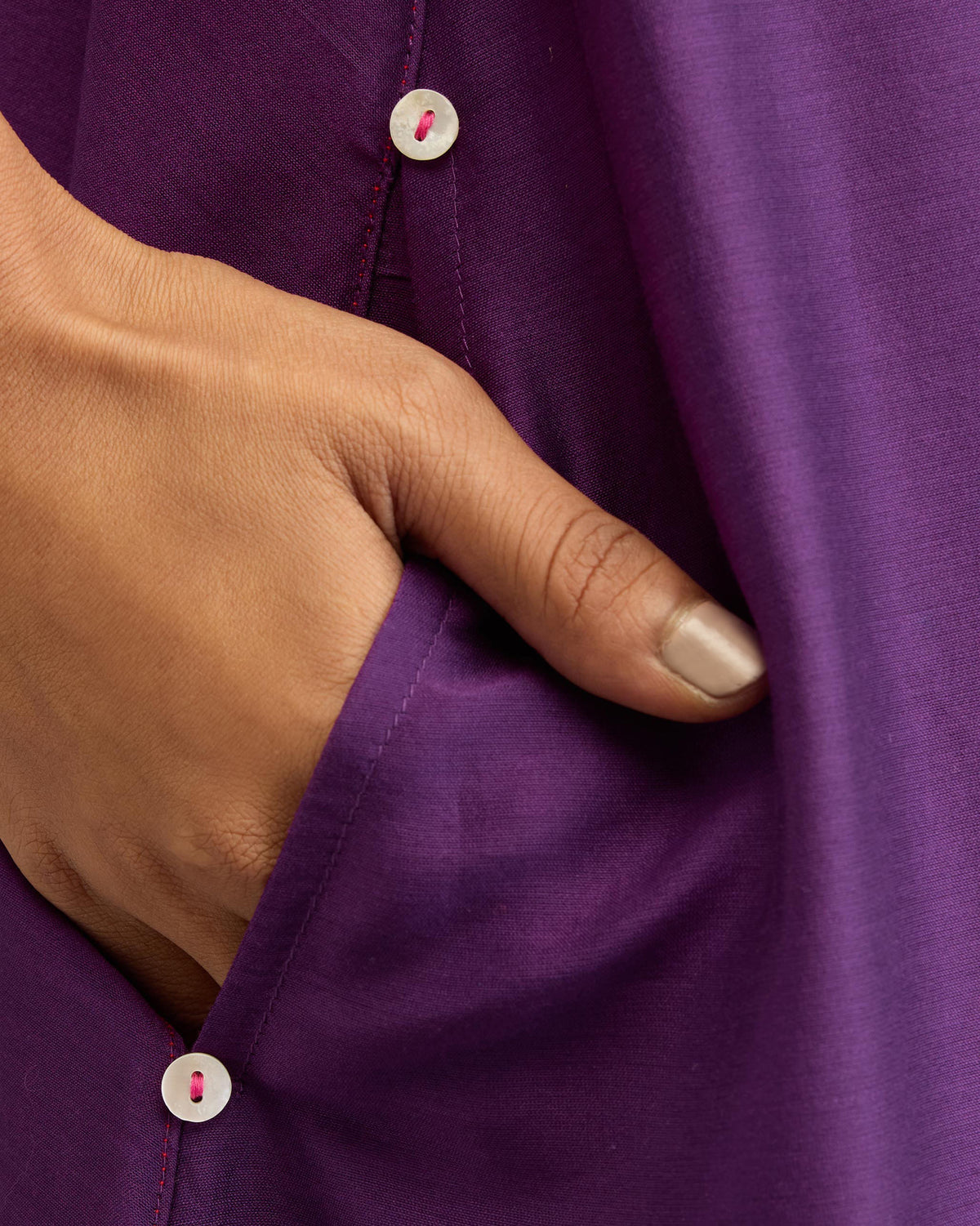 Close-up of a purple Chanderi A-line Double layer dress showing a side pocket with white buttons.